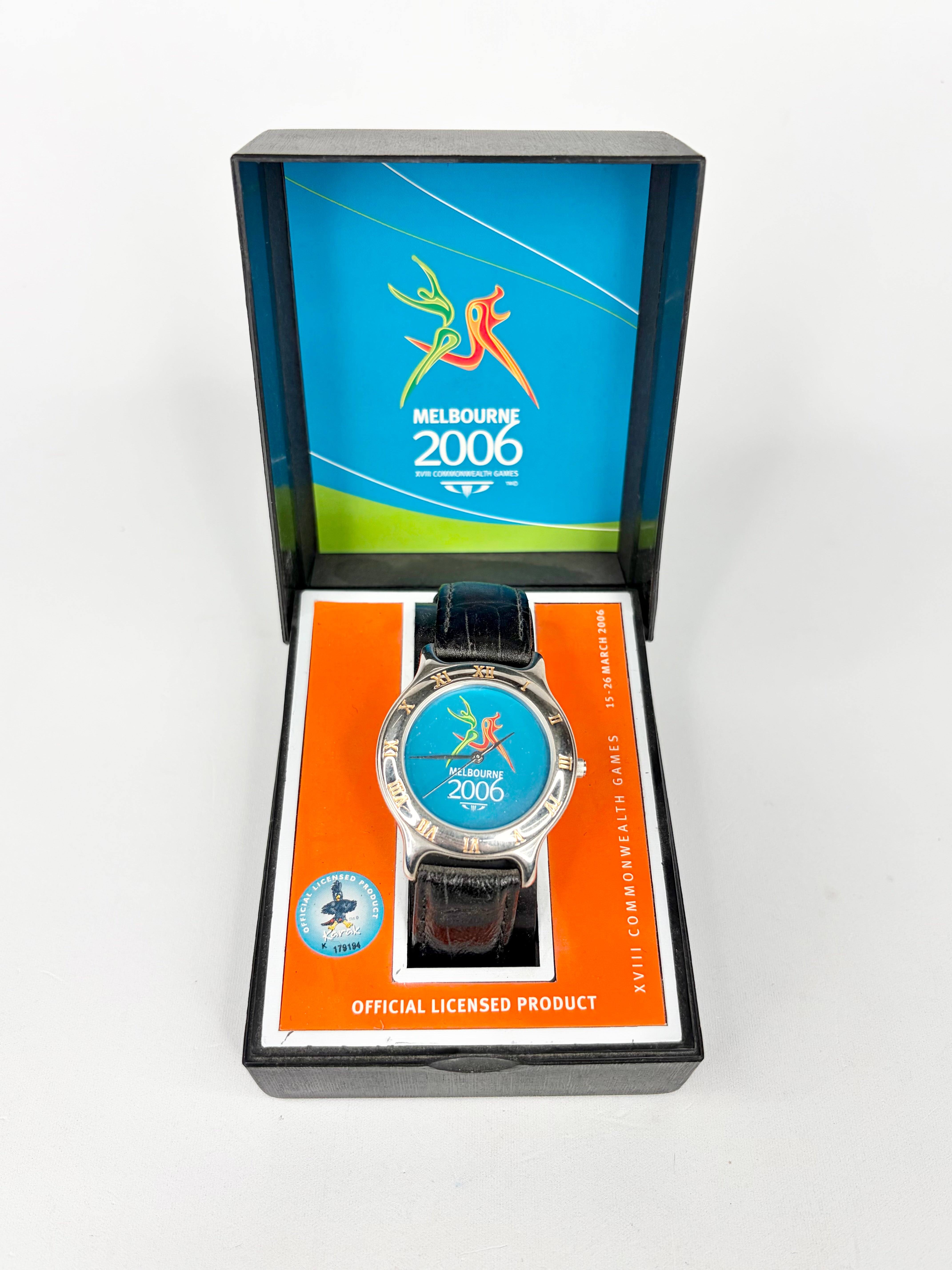 Watch with Melbourne 2006 branding in a display box on a white background