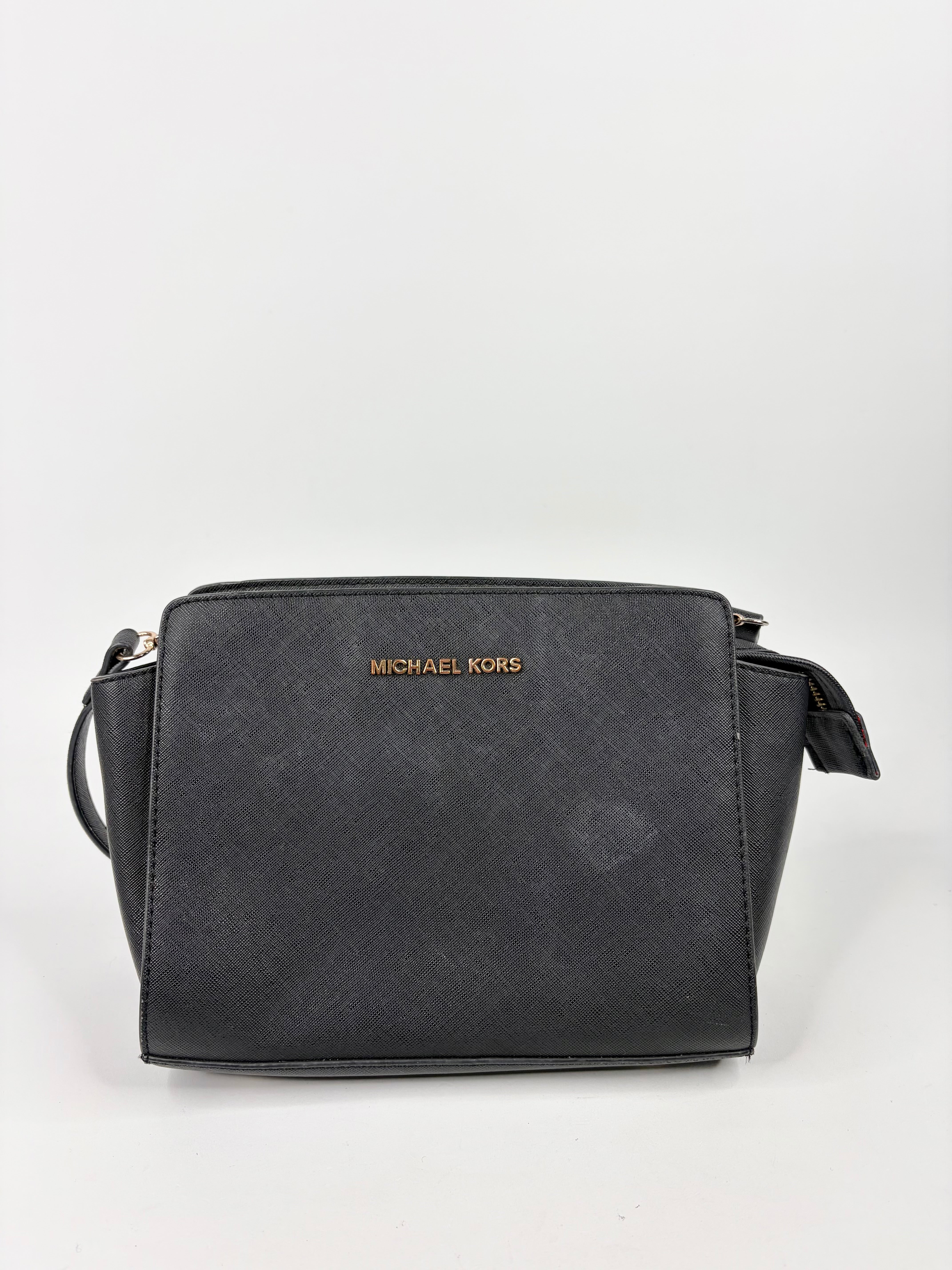 Black handbag with 'Michael Kors' logo on a light gray background