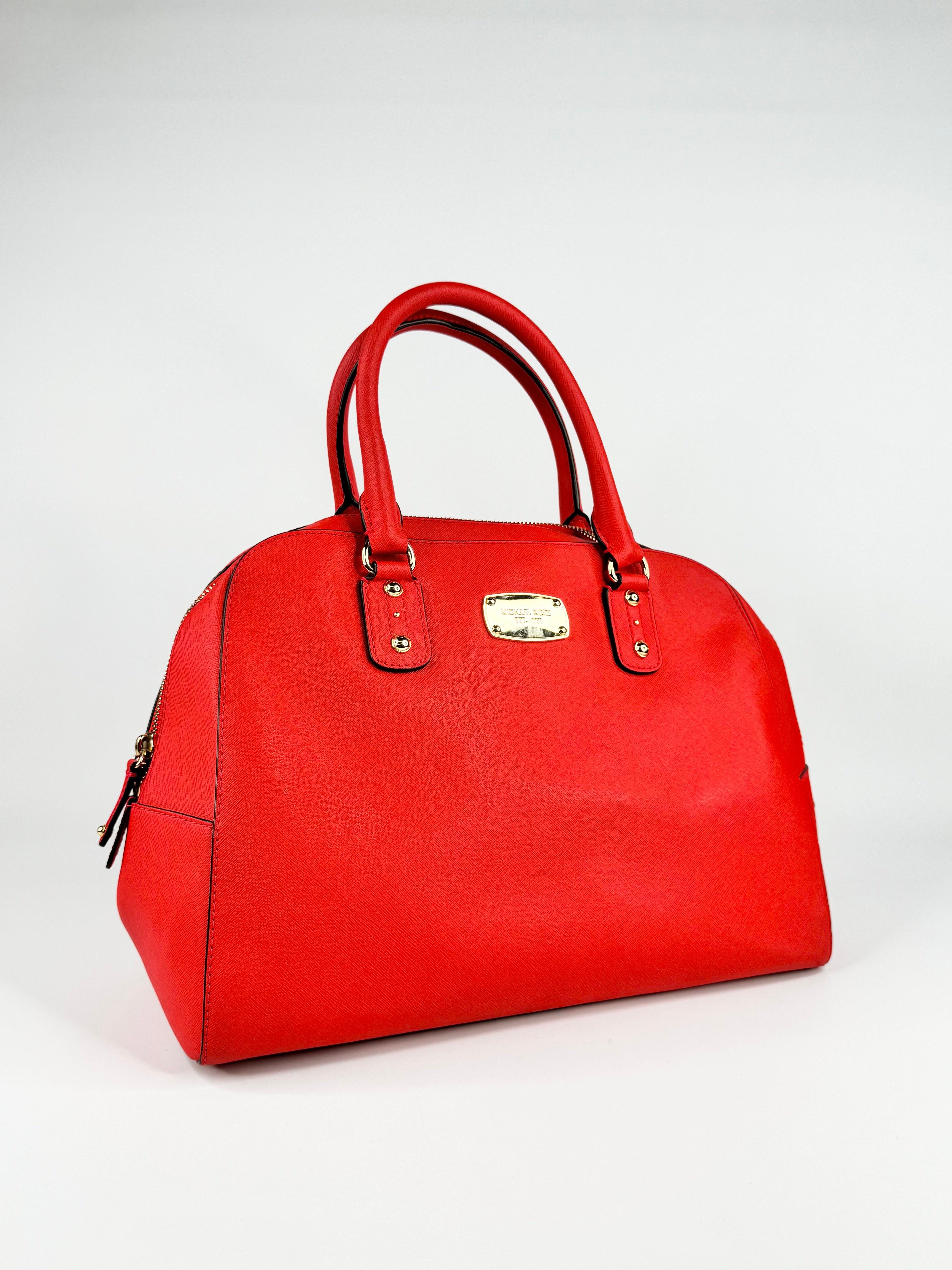 Red handbag with gold accents on a light gray background