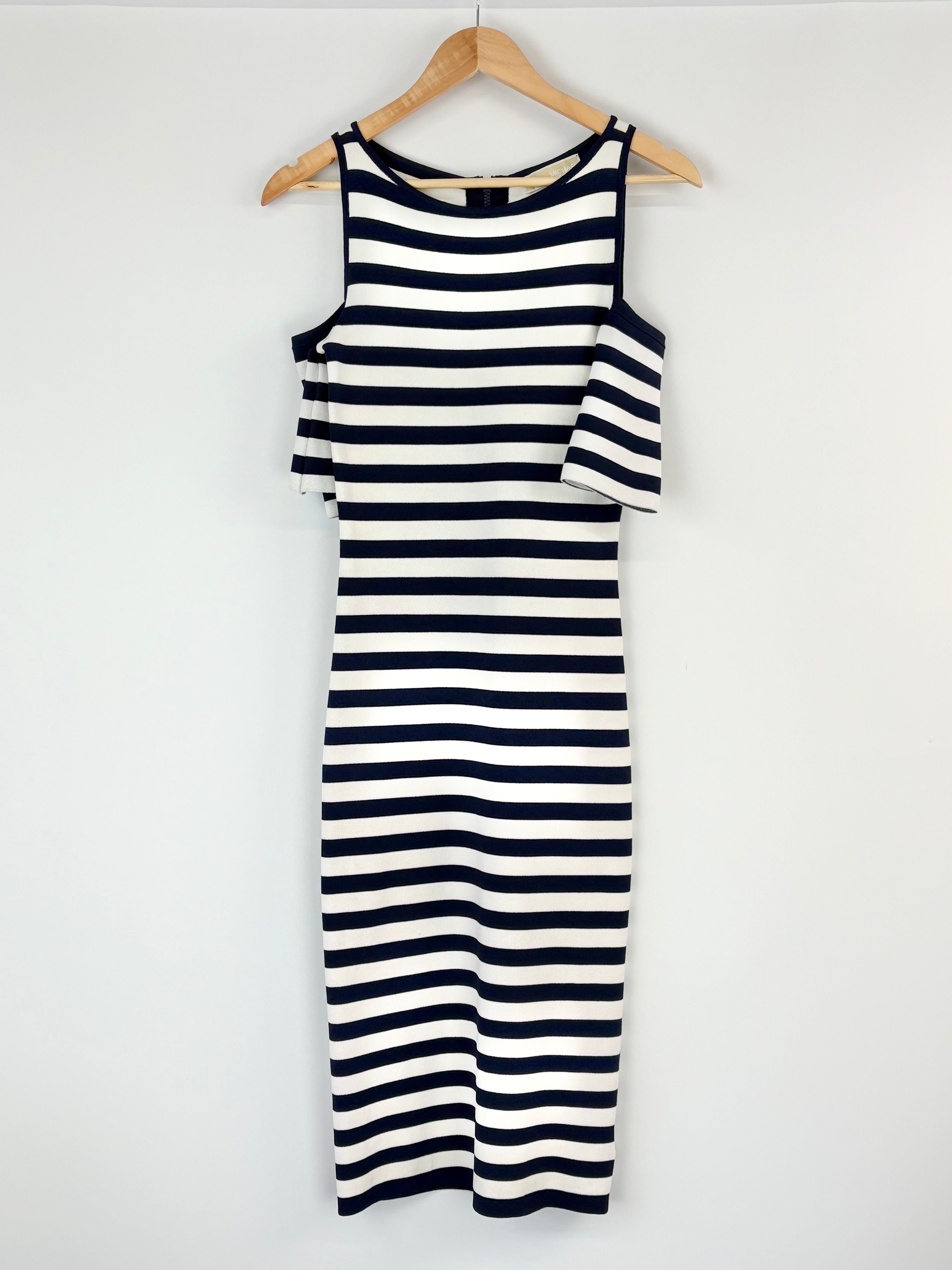 Navy and white striped dress on a hanger against a white background