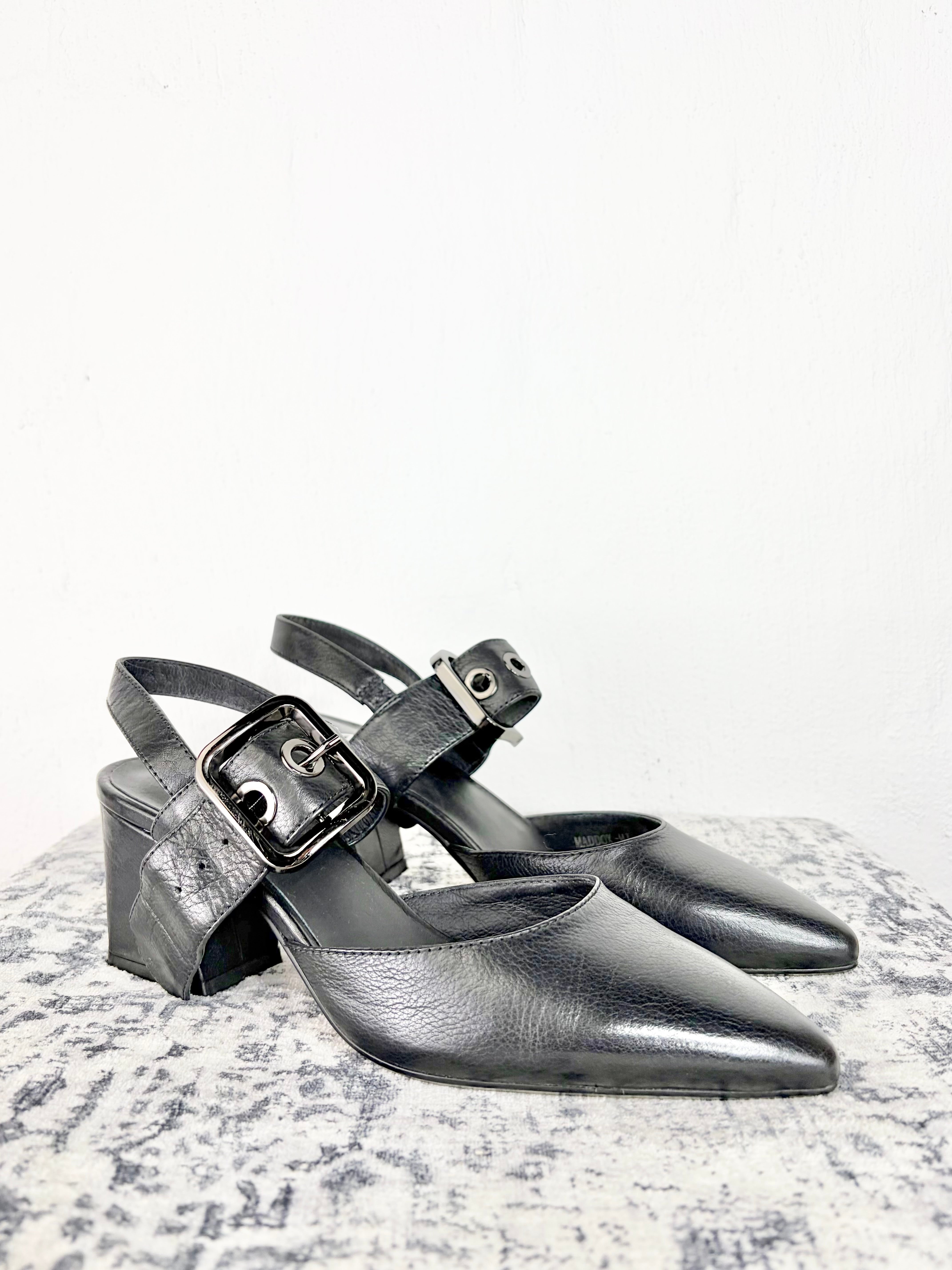 Black buckled heels on white background