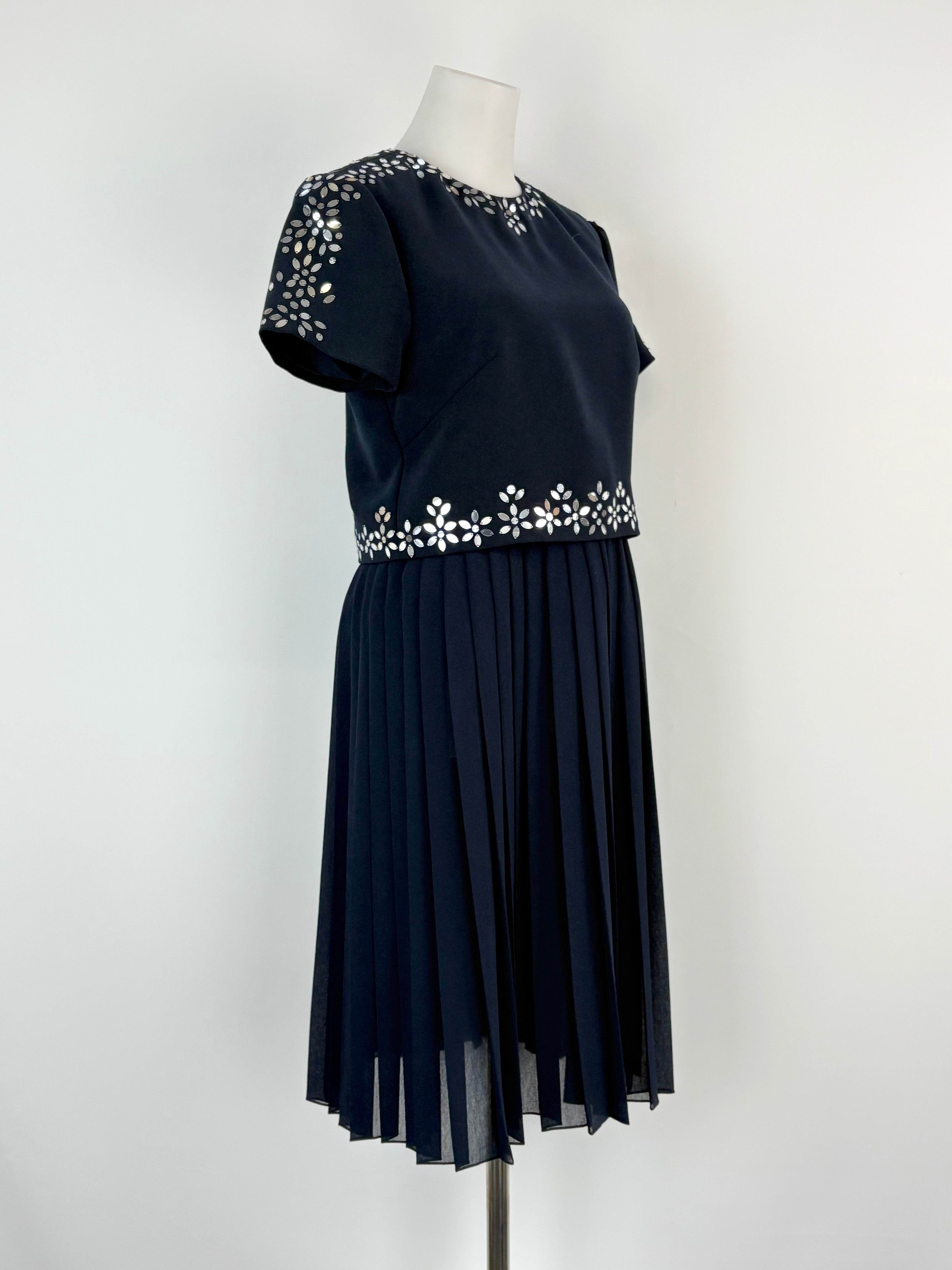 Navy blue dress with floral embellishments on a white background