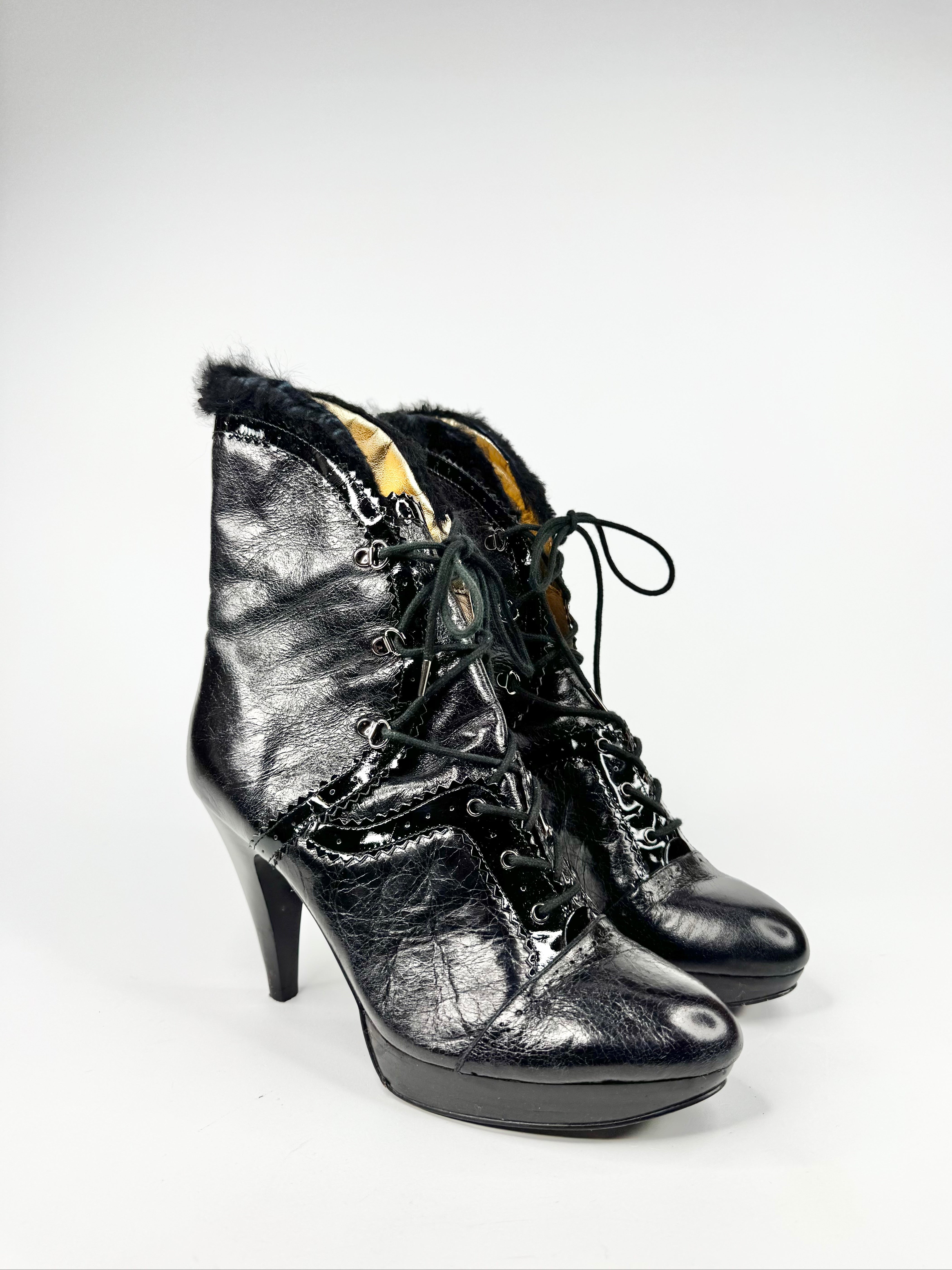 Black high-heeled boots with fur trim on a white background