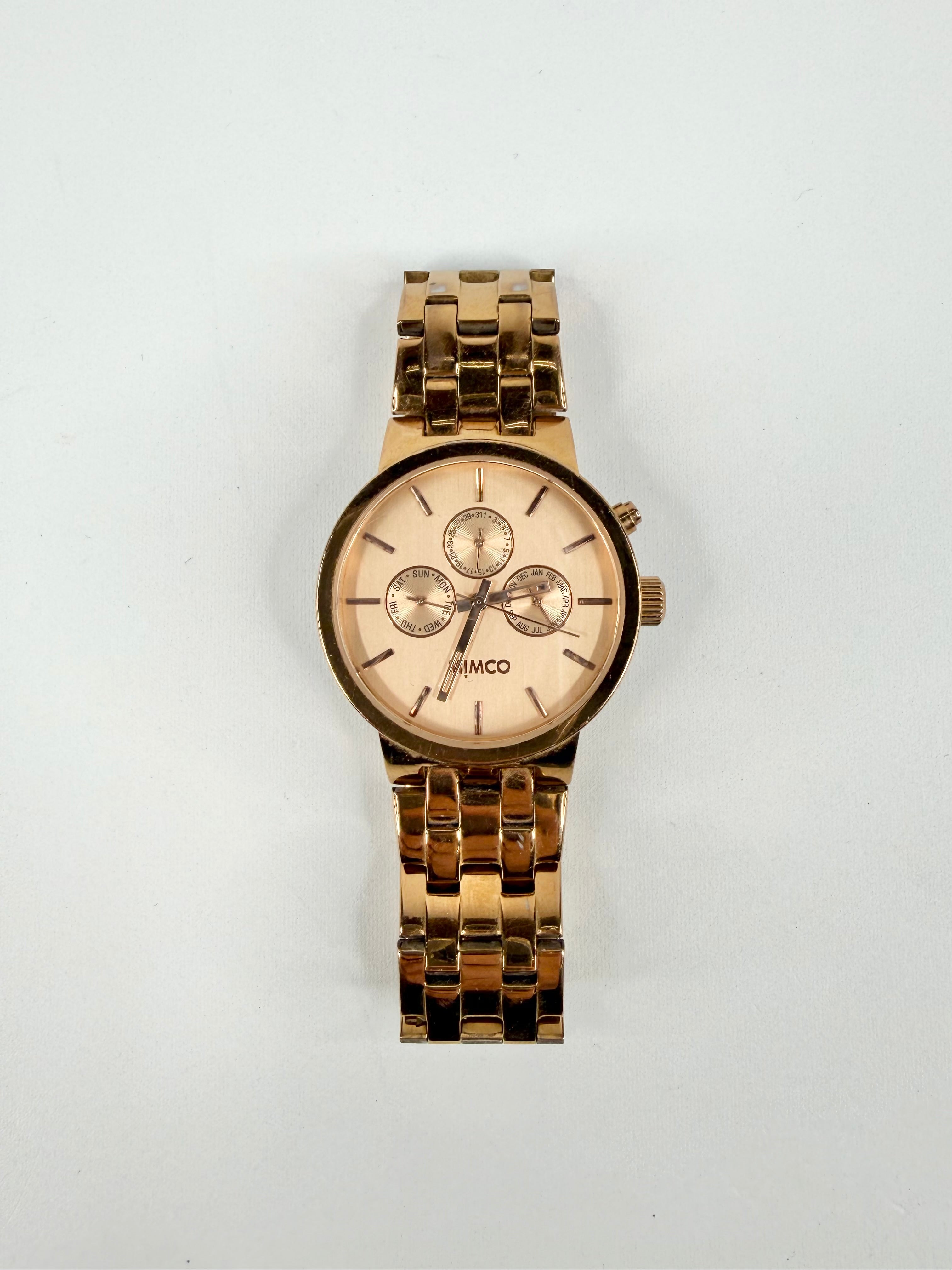 Gold watch with a light face on a white background