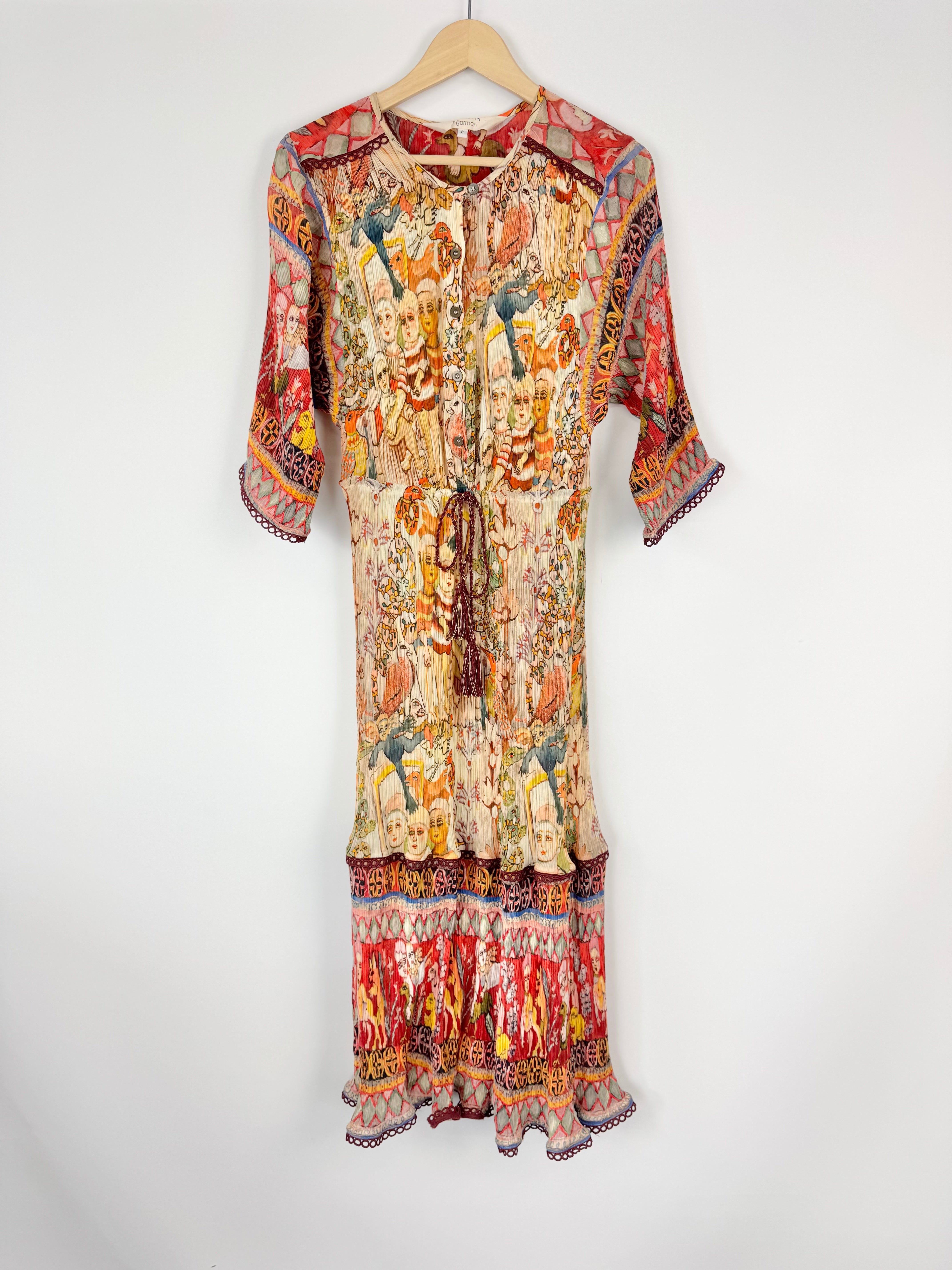 Colorful patterned dress on a hanger against a white background