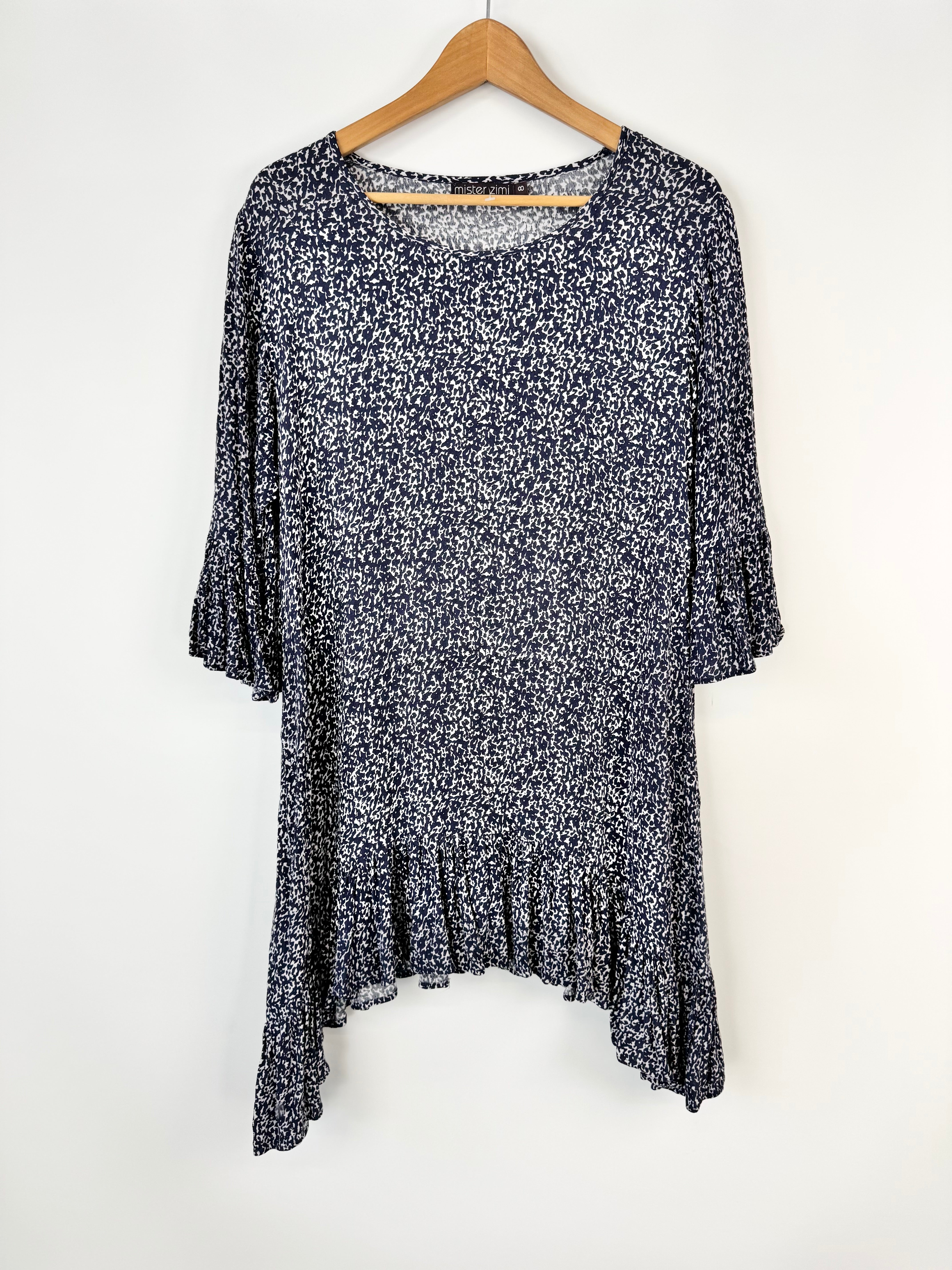 Floral patterned dress on a hanger against a white background
