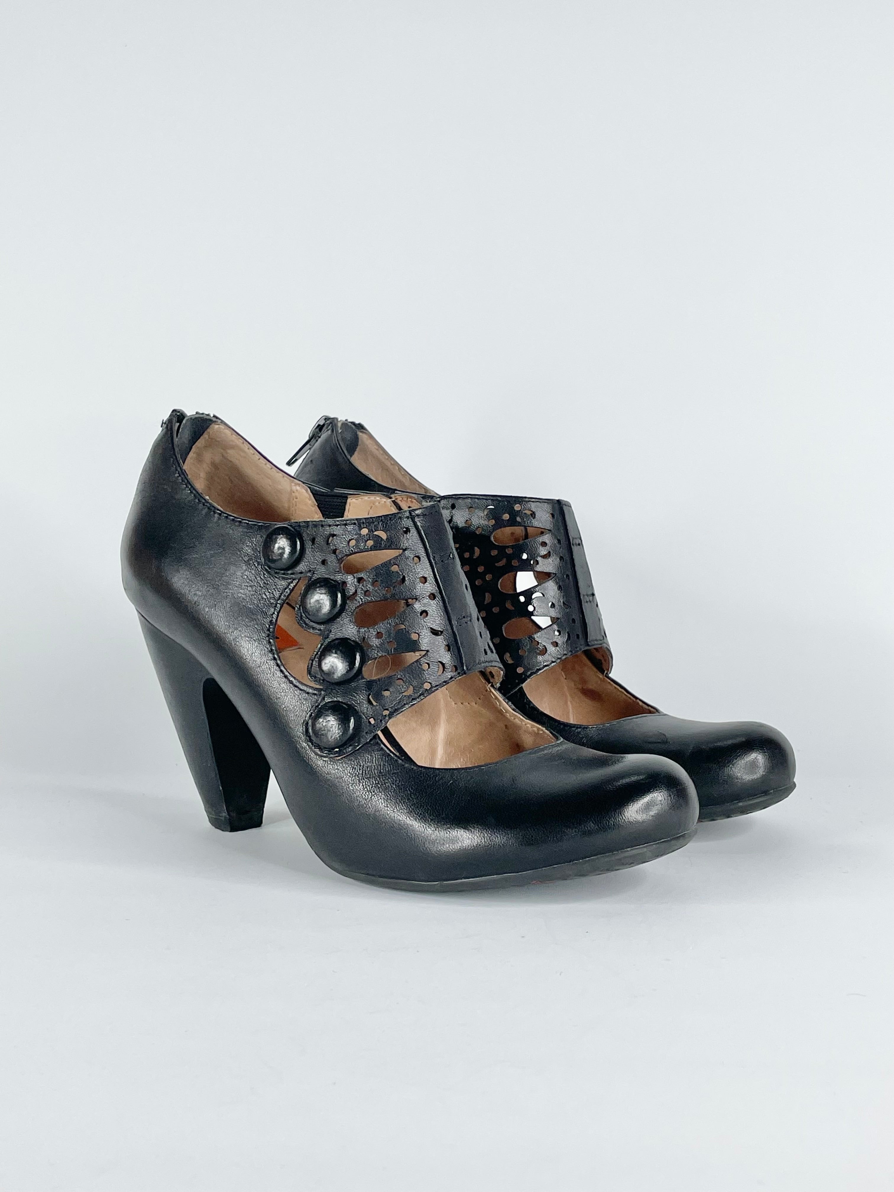 Black leather 'Sharon' Mary Jane pumps with a cut to leather on left toe and a visible heel strap.