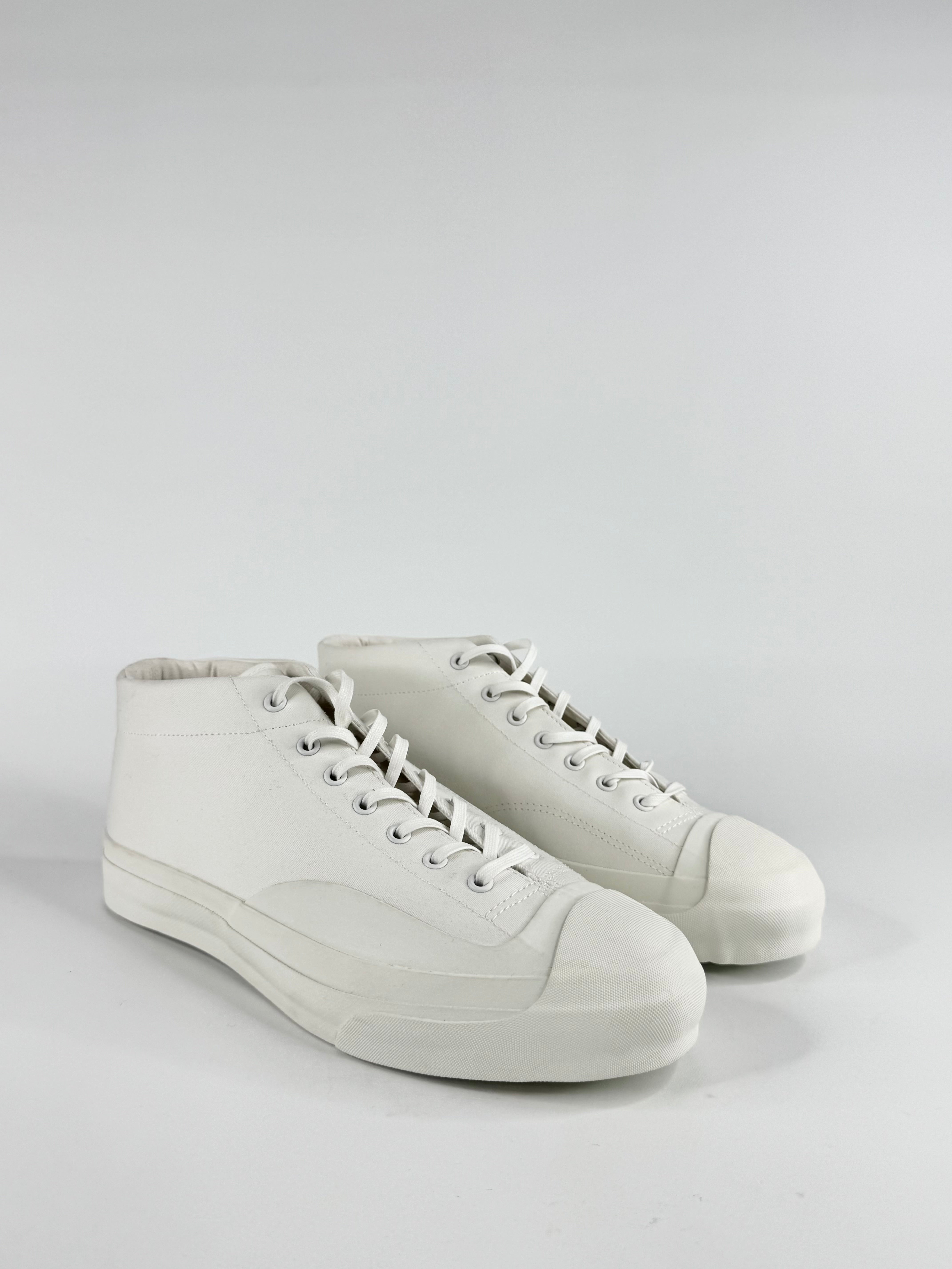 White high-top sneakers on a light gray background