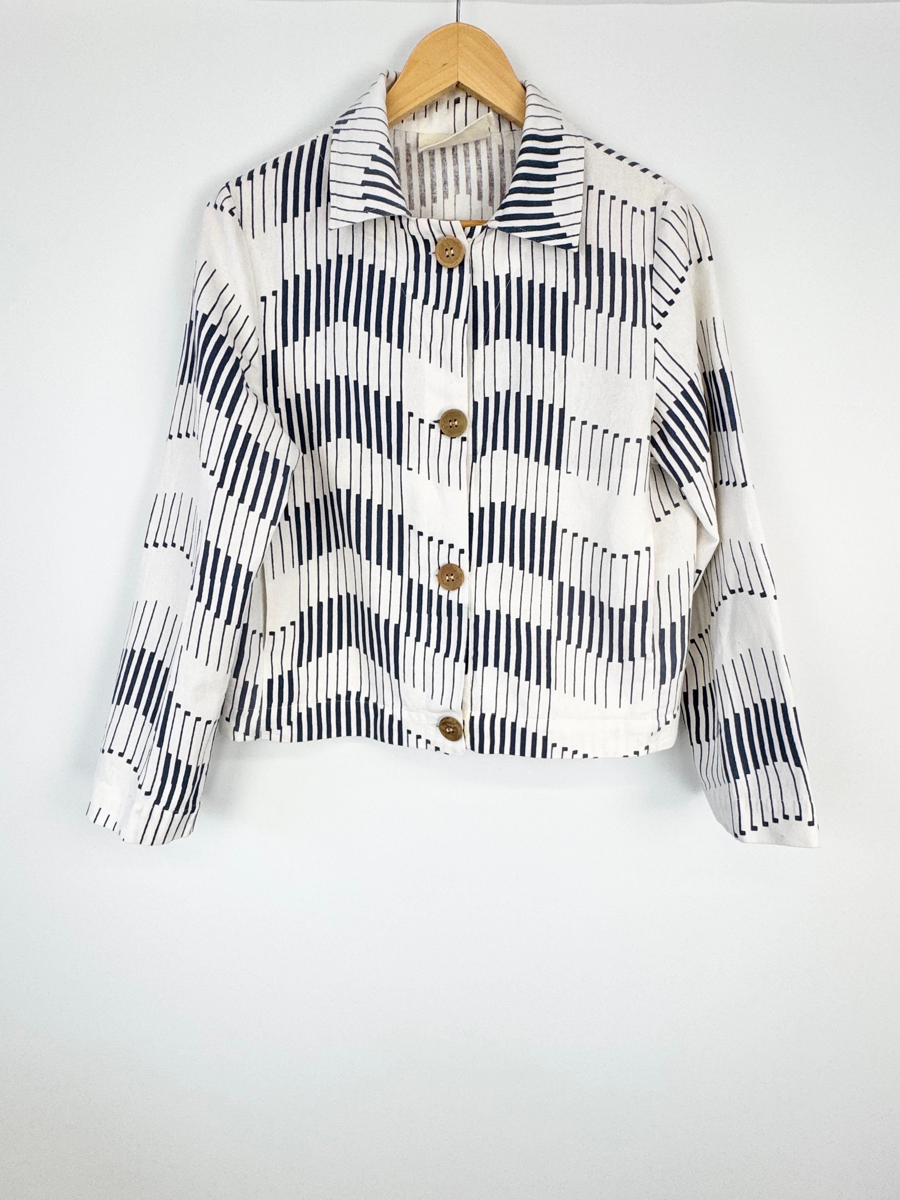 Black and white checkered shirt with wooden buttons on a hanger against a white background