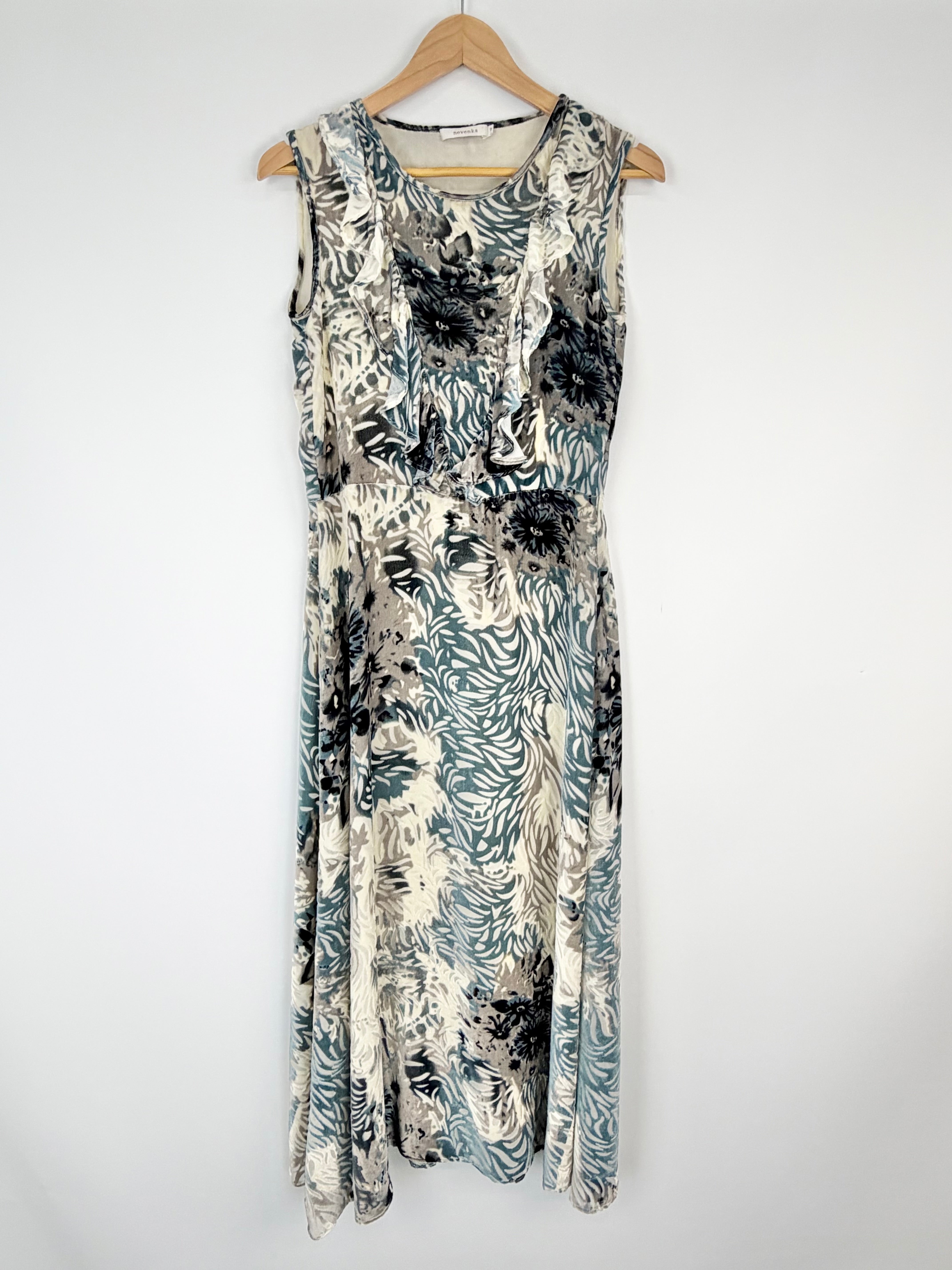 Floral patterned dress on a hanger against a white background