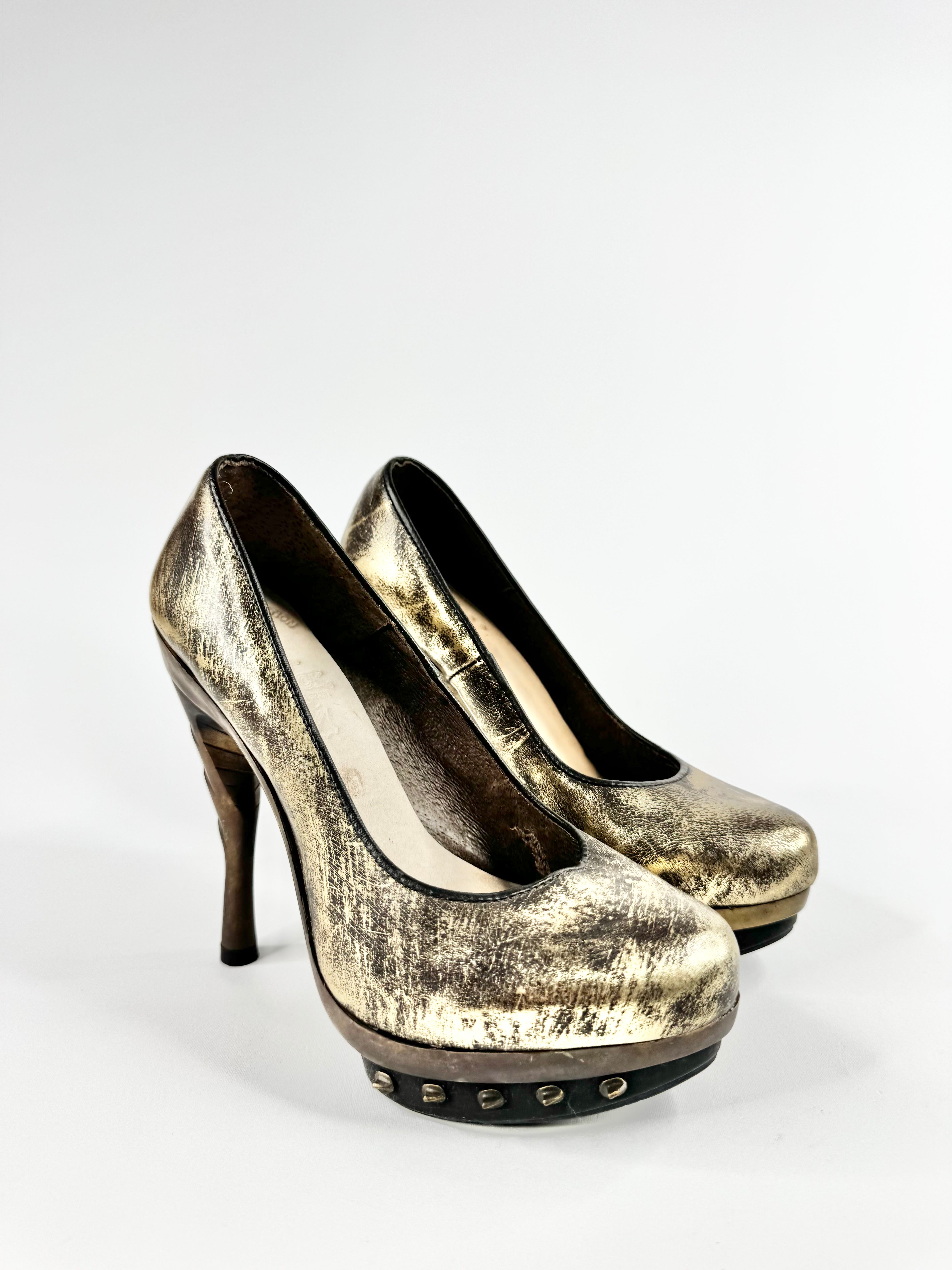 Pair of gold high-heeled shoes on a white background