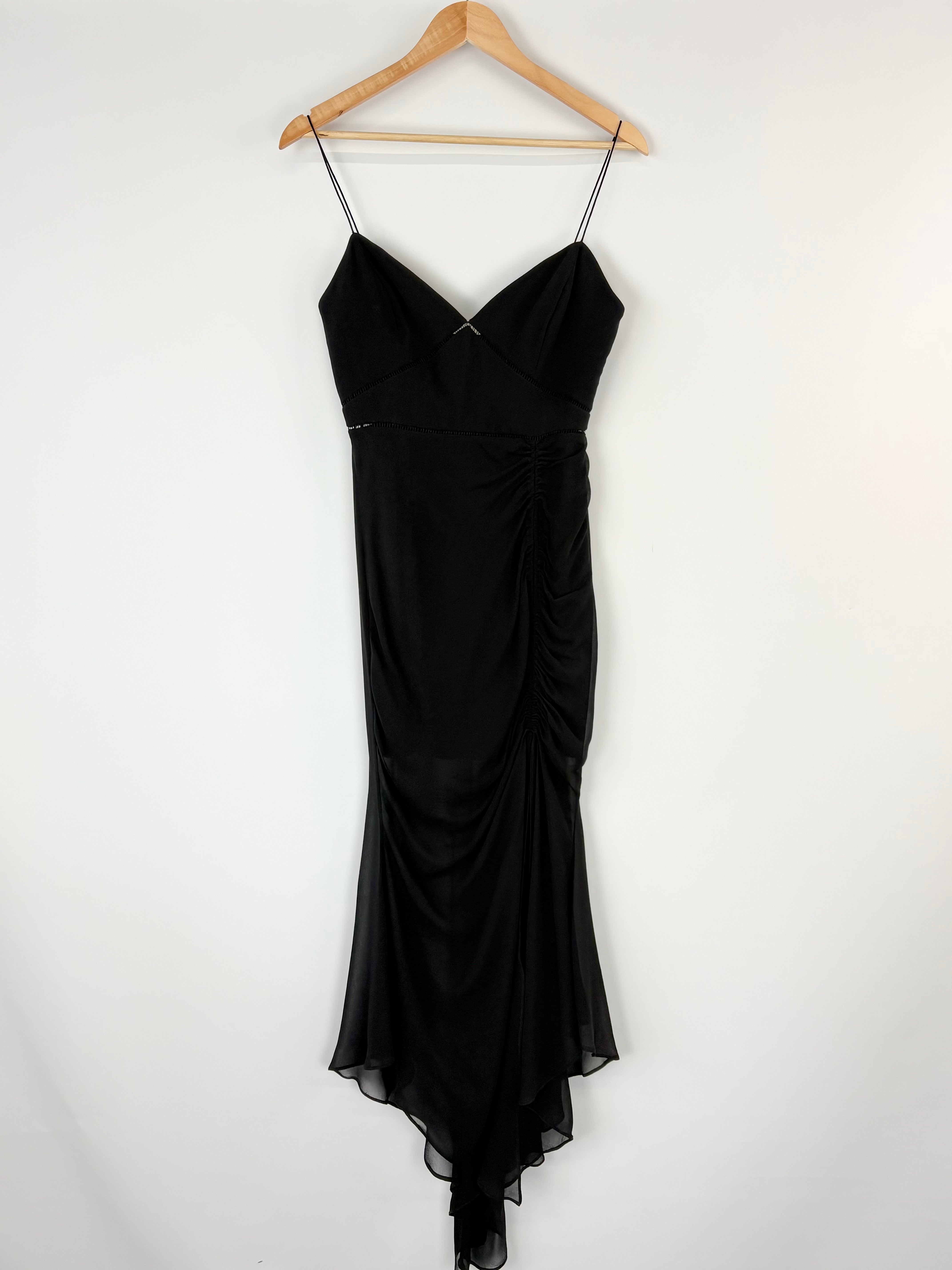 Black dress on a hanger against a white background