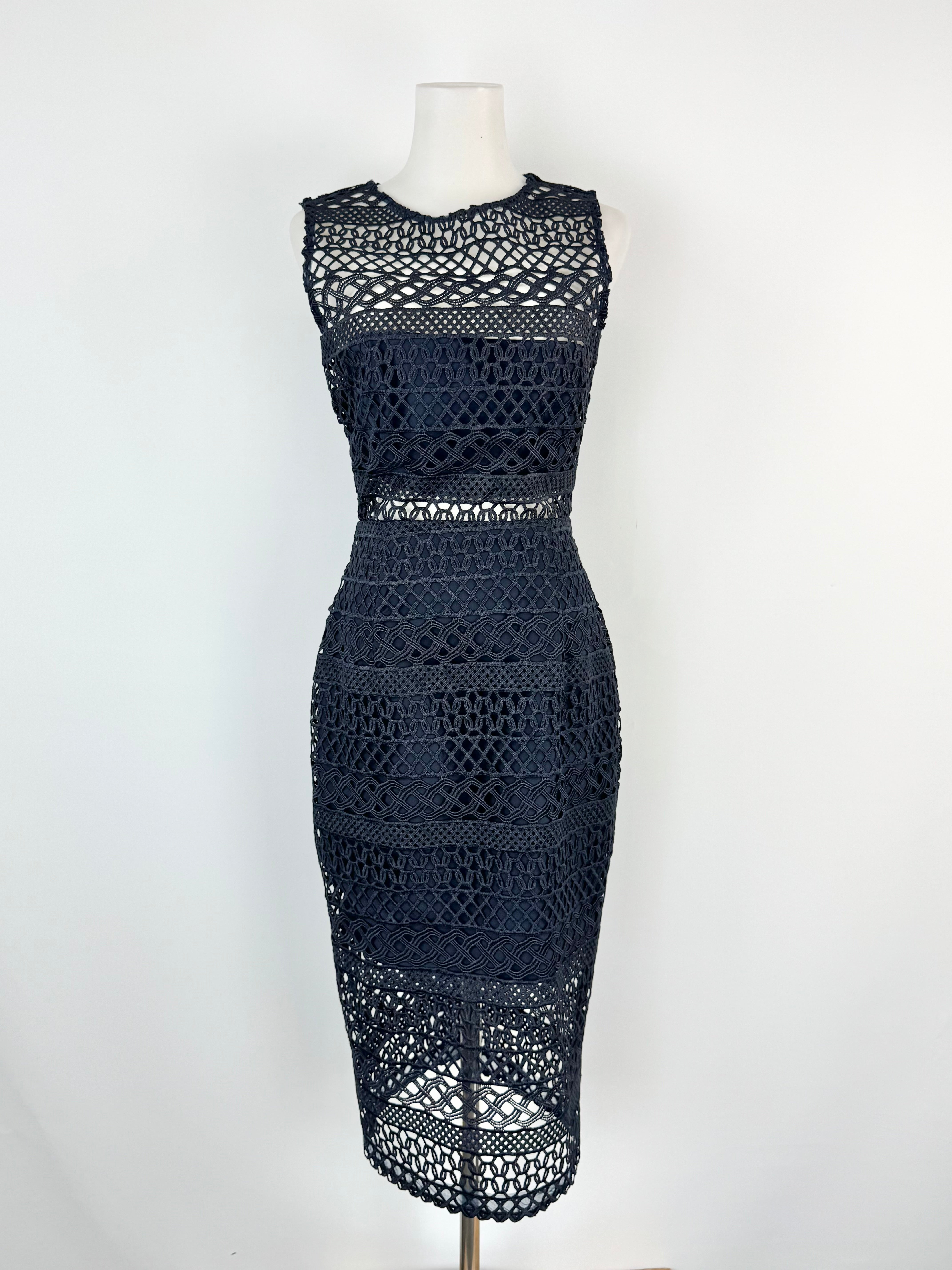 Navy blue crochet dress on a mannequin against a white background