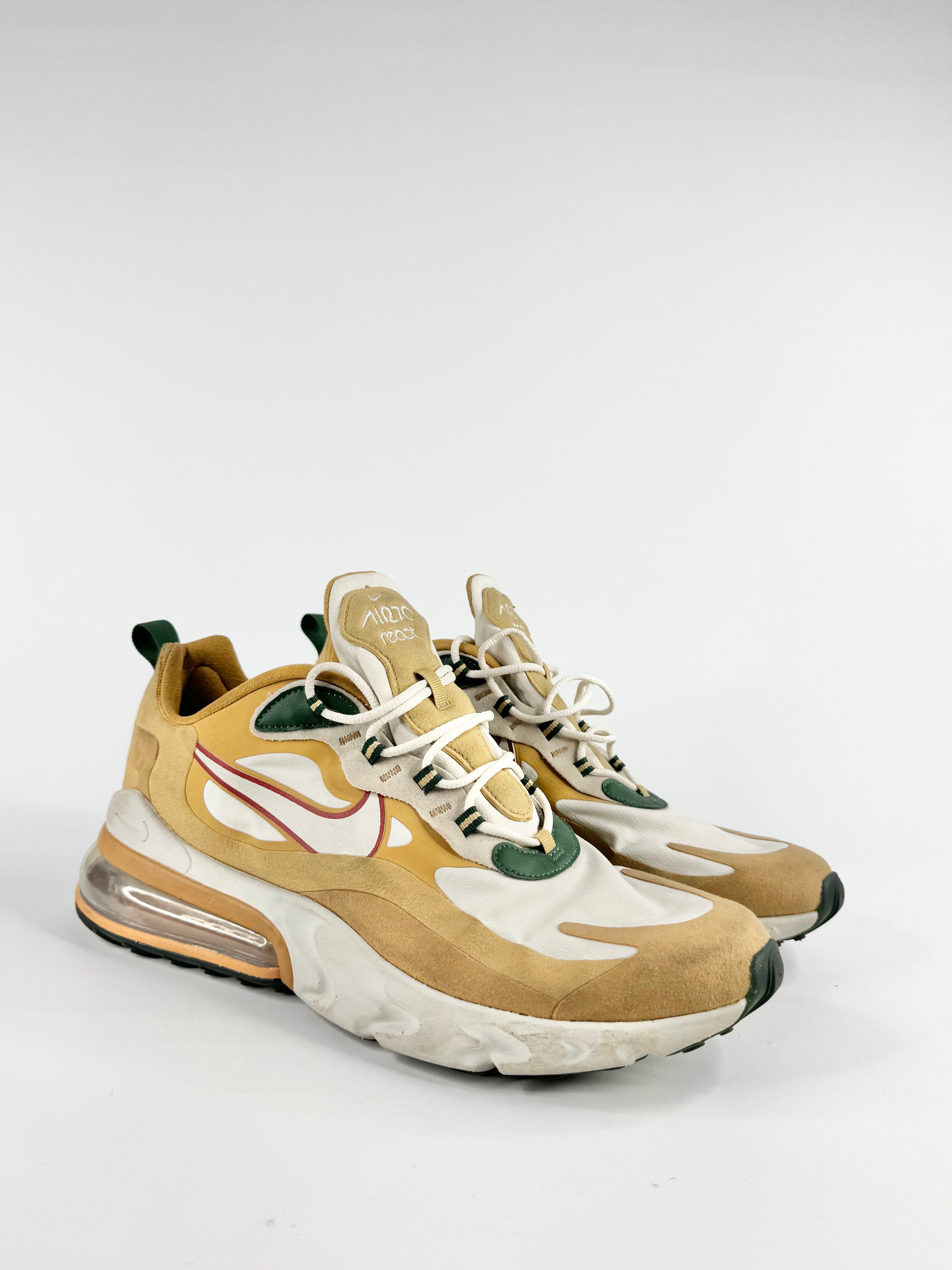 Beige and white sneakers with green accents on a light gray background