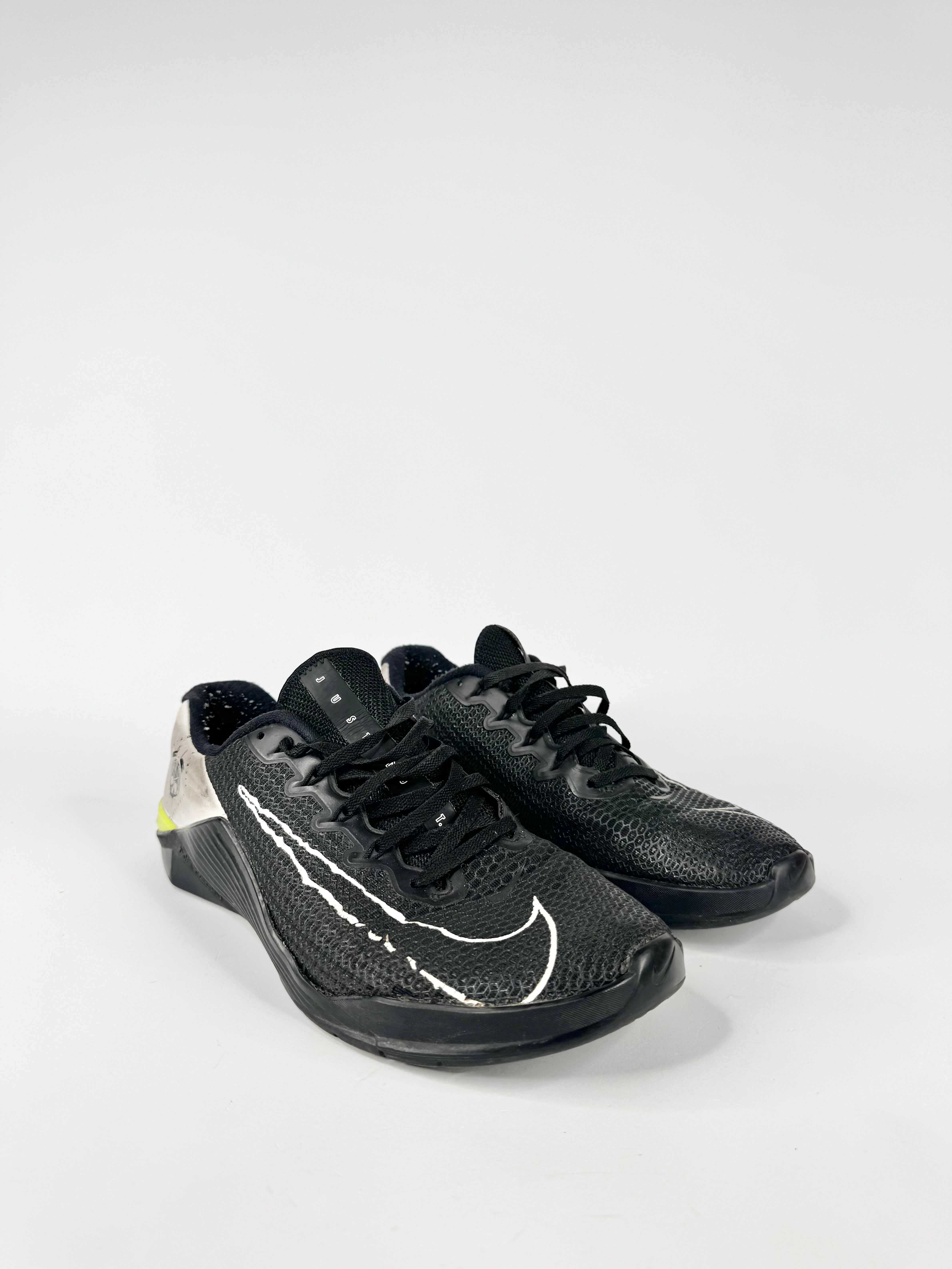 Black athletic shoes with a white logo on a white background