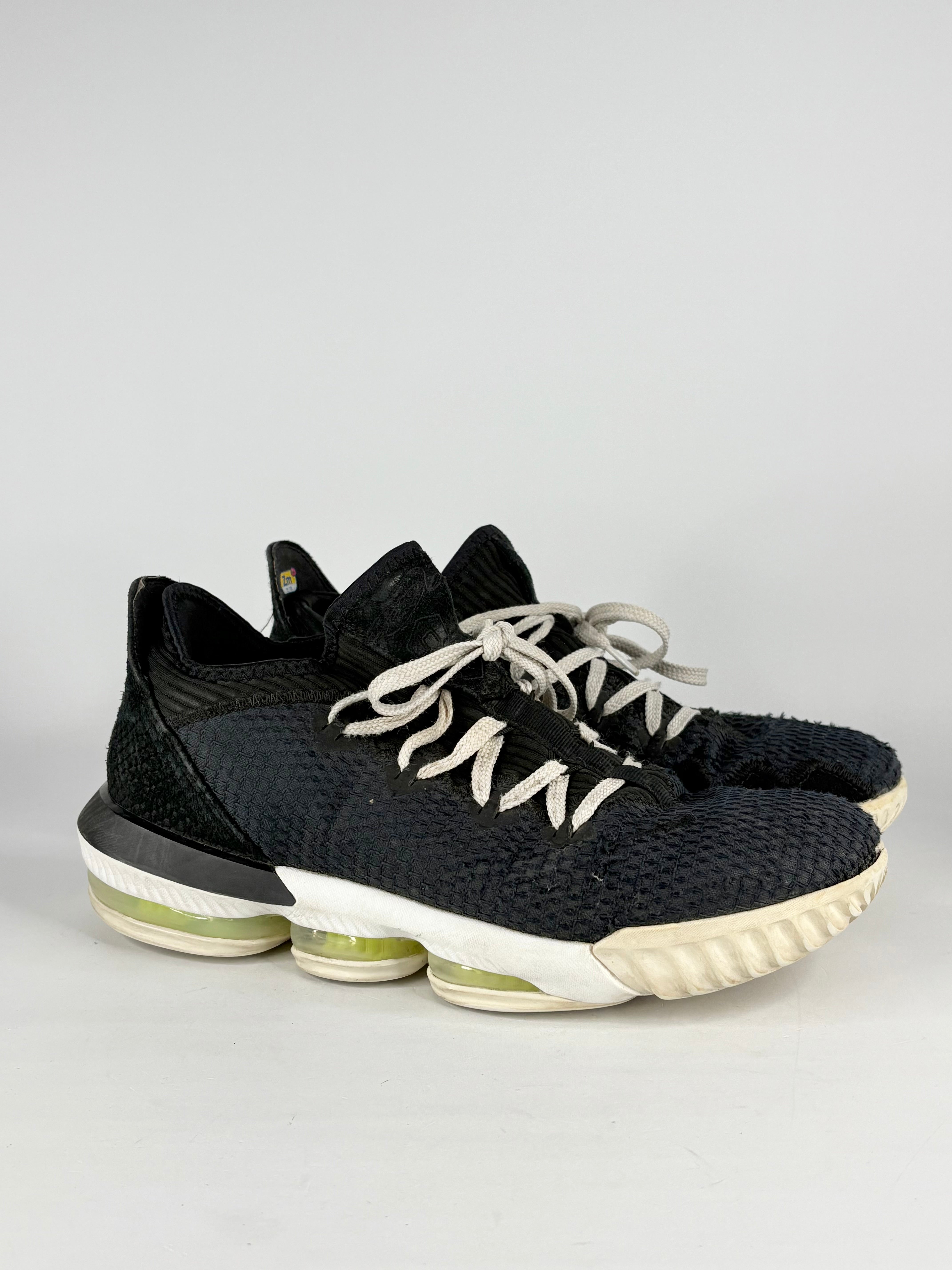 Black sneakers with white soles on a light gray background