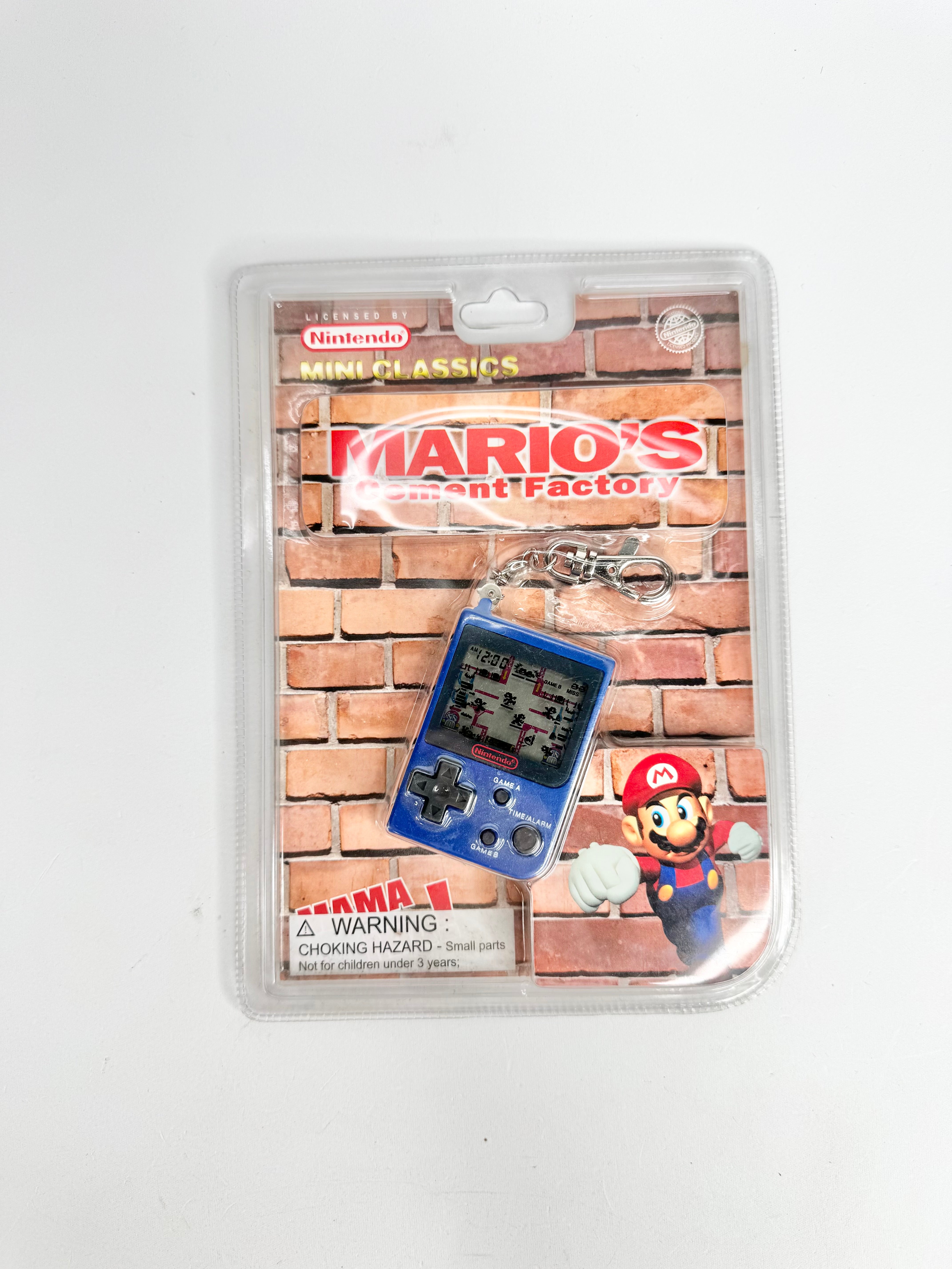 Packaged Mario's Game & Watch keychain with brick wall design on a white background