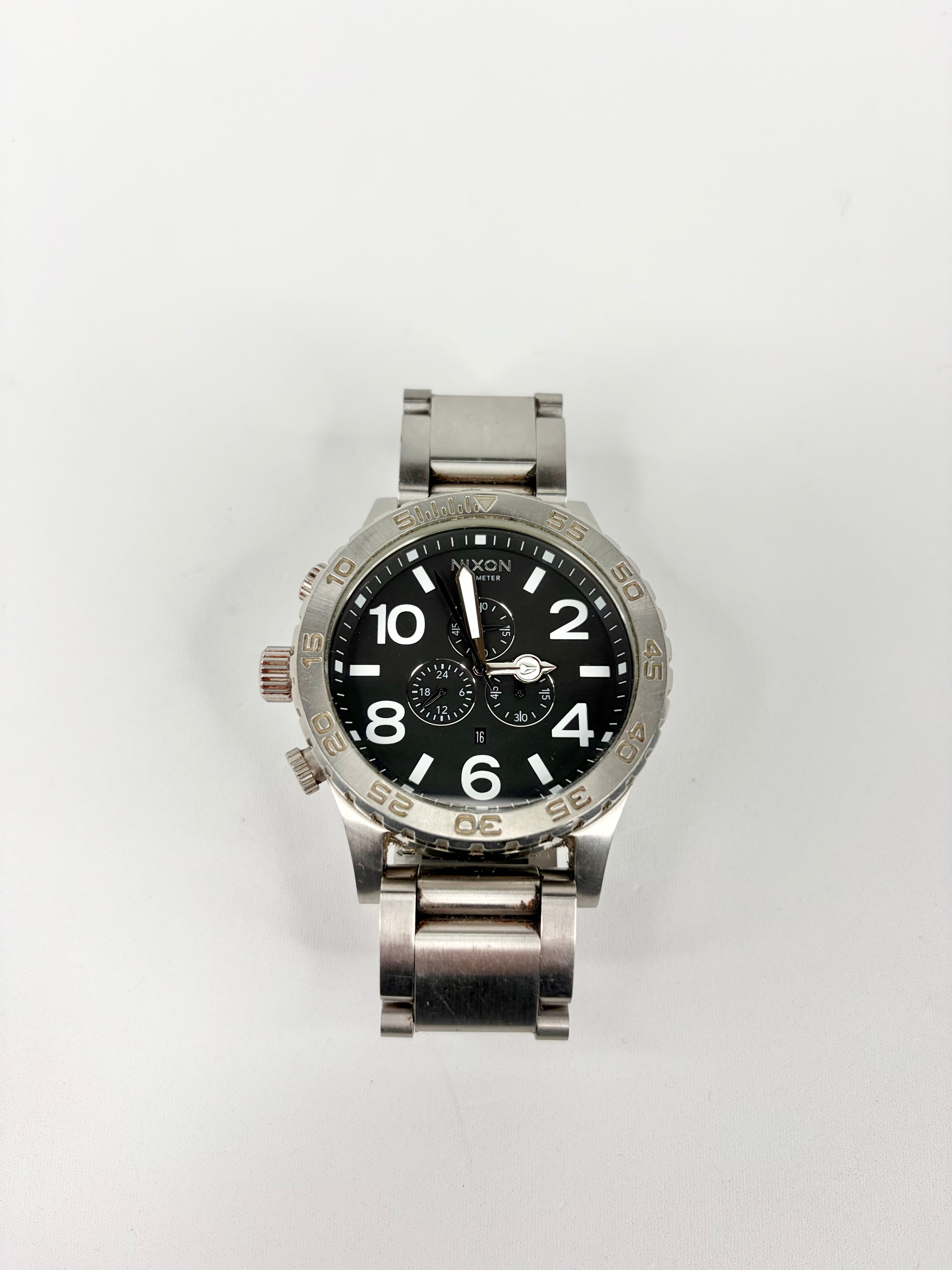 Silver watch with a black face on a white background