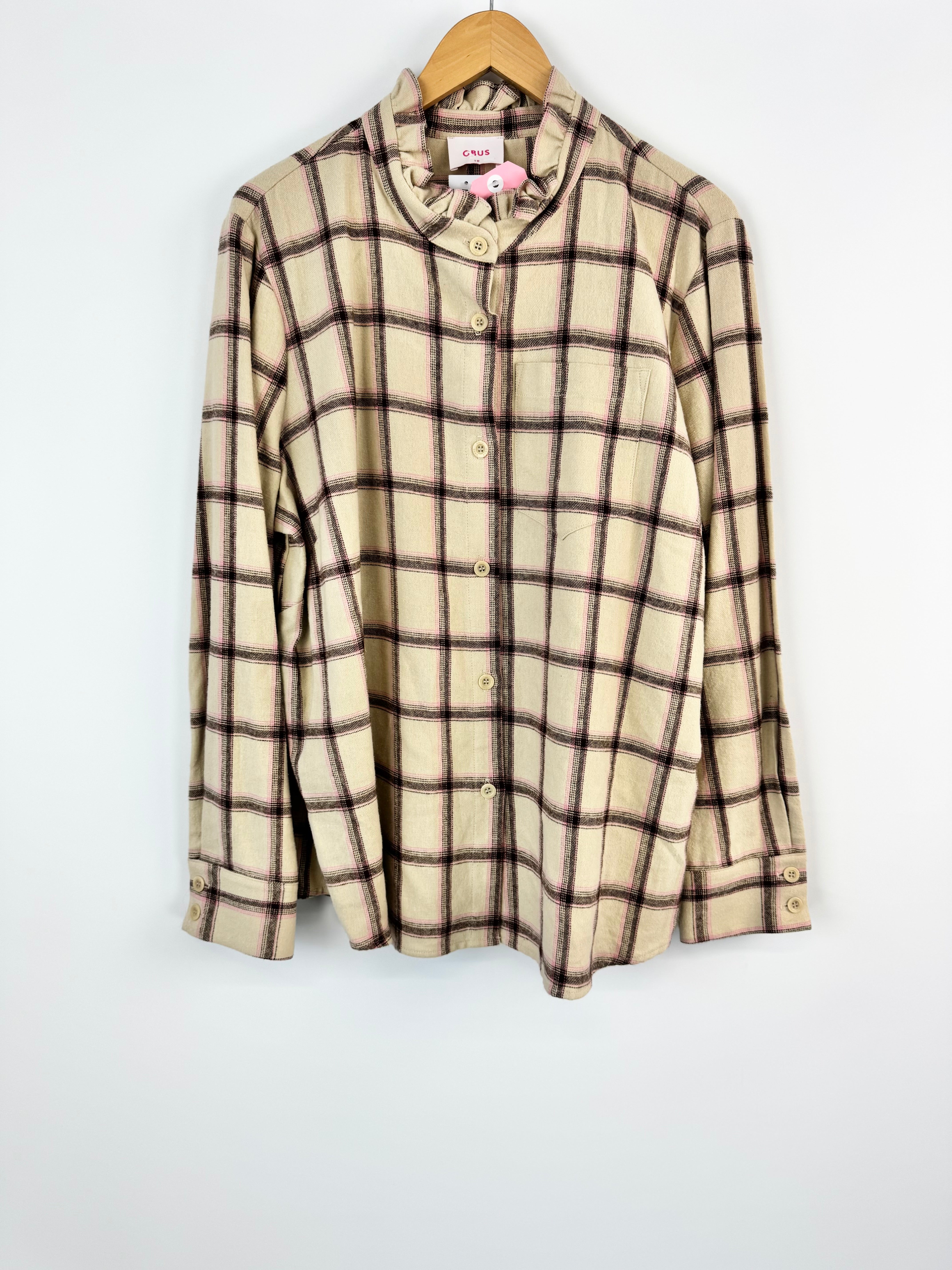 Plaid shirt on a hanger against a white background