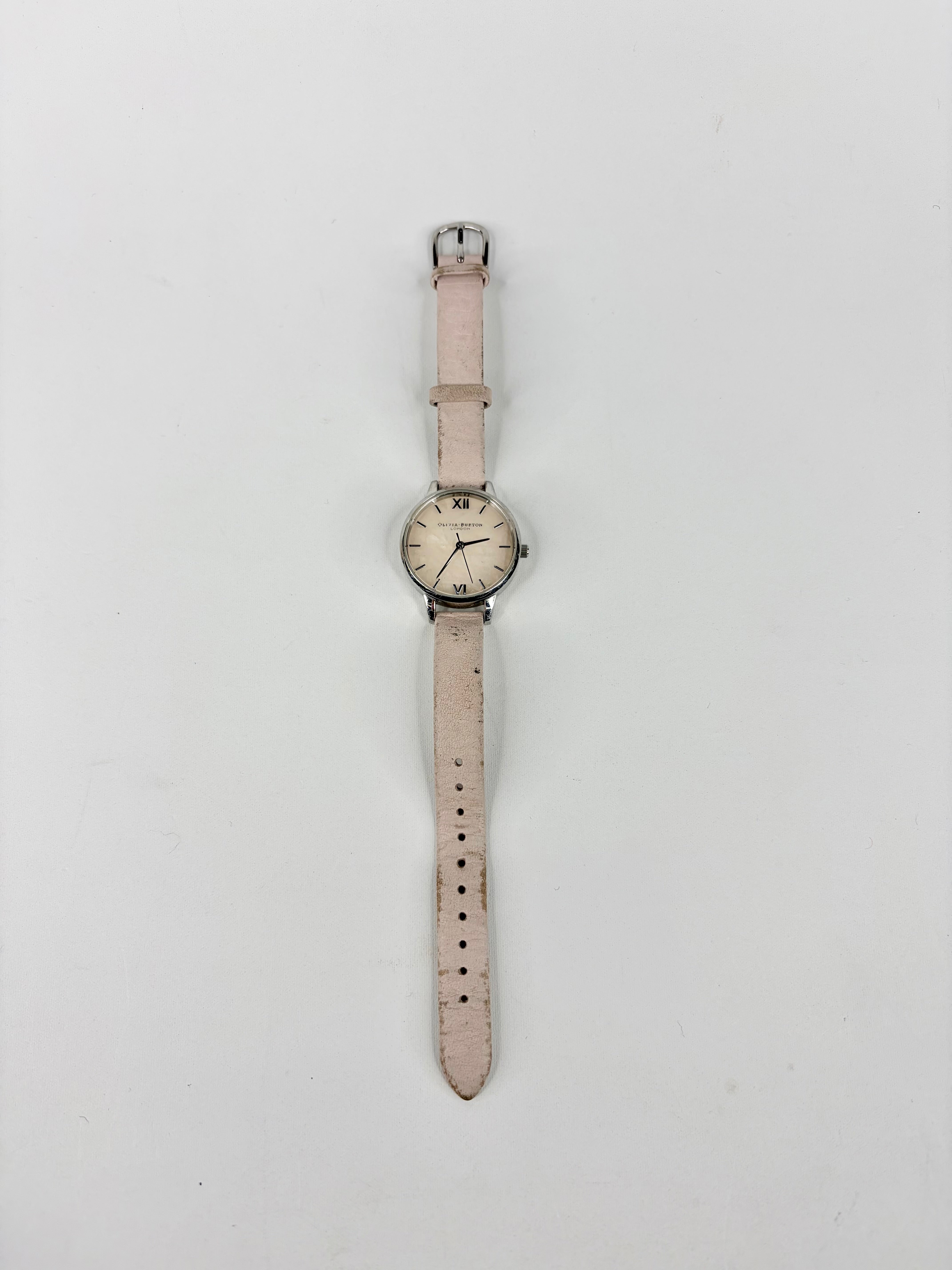 Wristwatch with a light pink strap on a white background