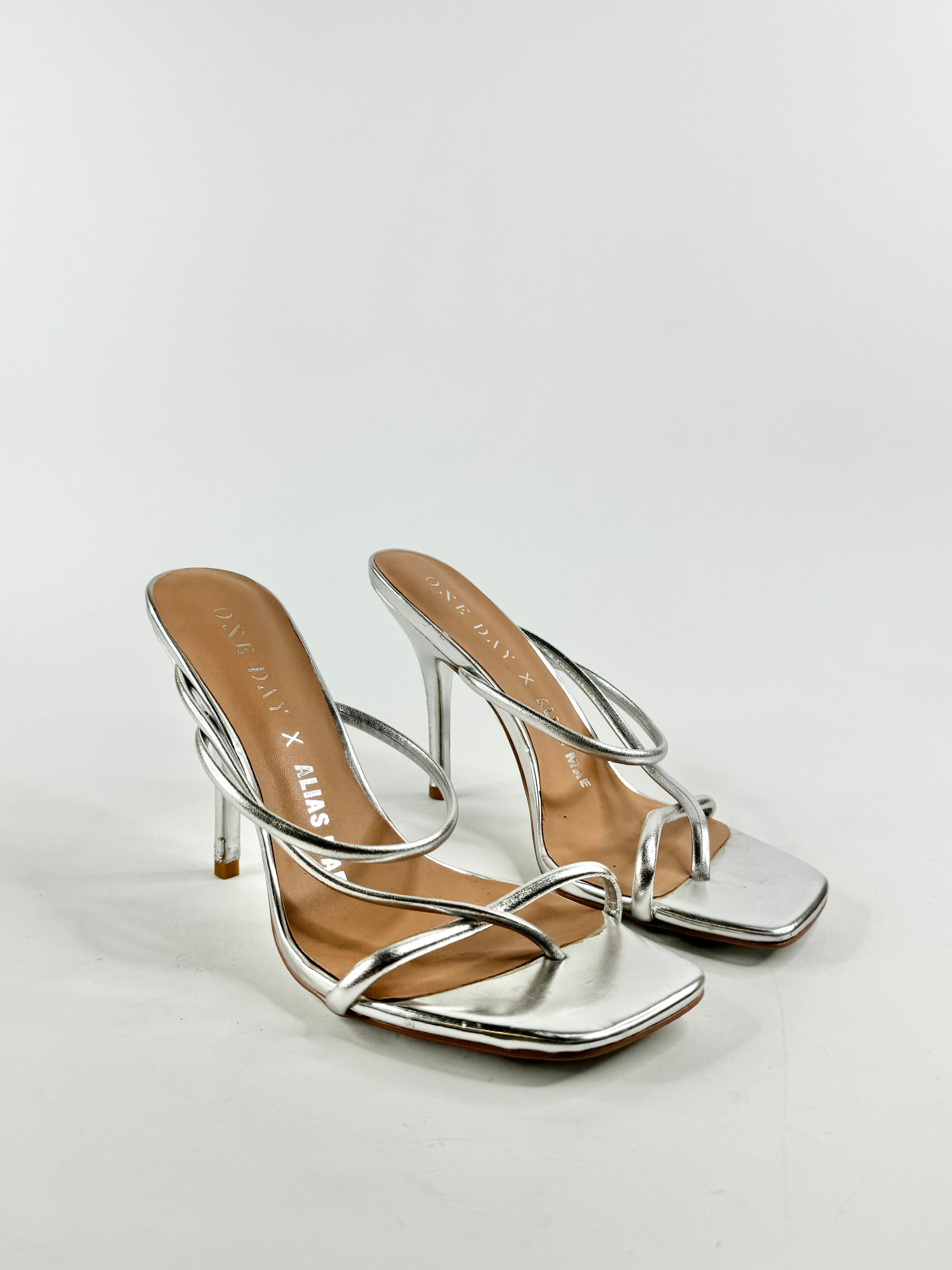 A pair of metallic silver stilettos with ankle straps, EU39 size, with visible signs of wear