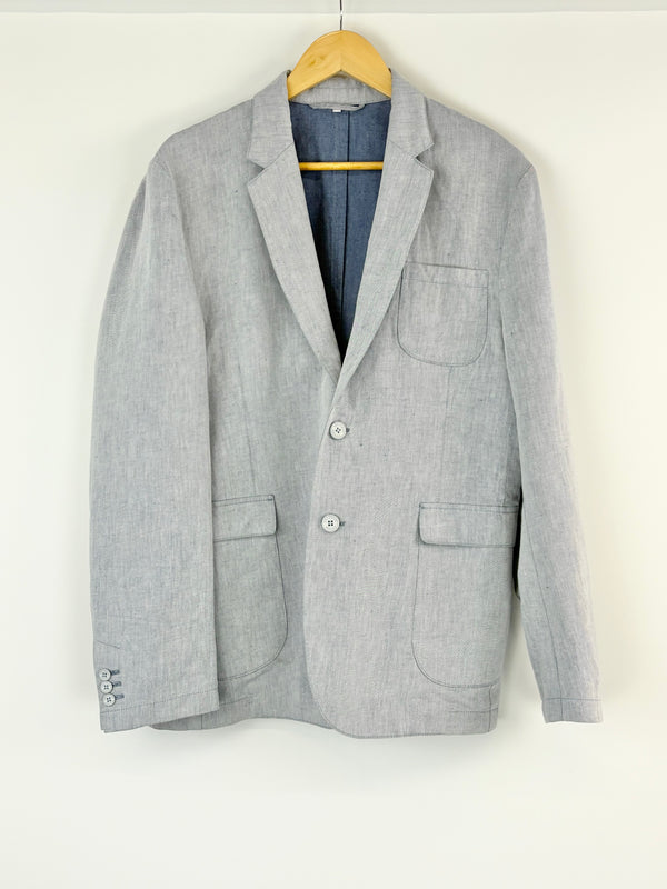 Blue blazer on a hanger against a white background