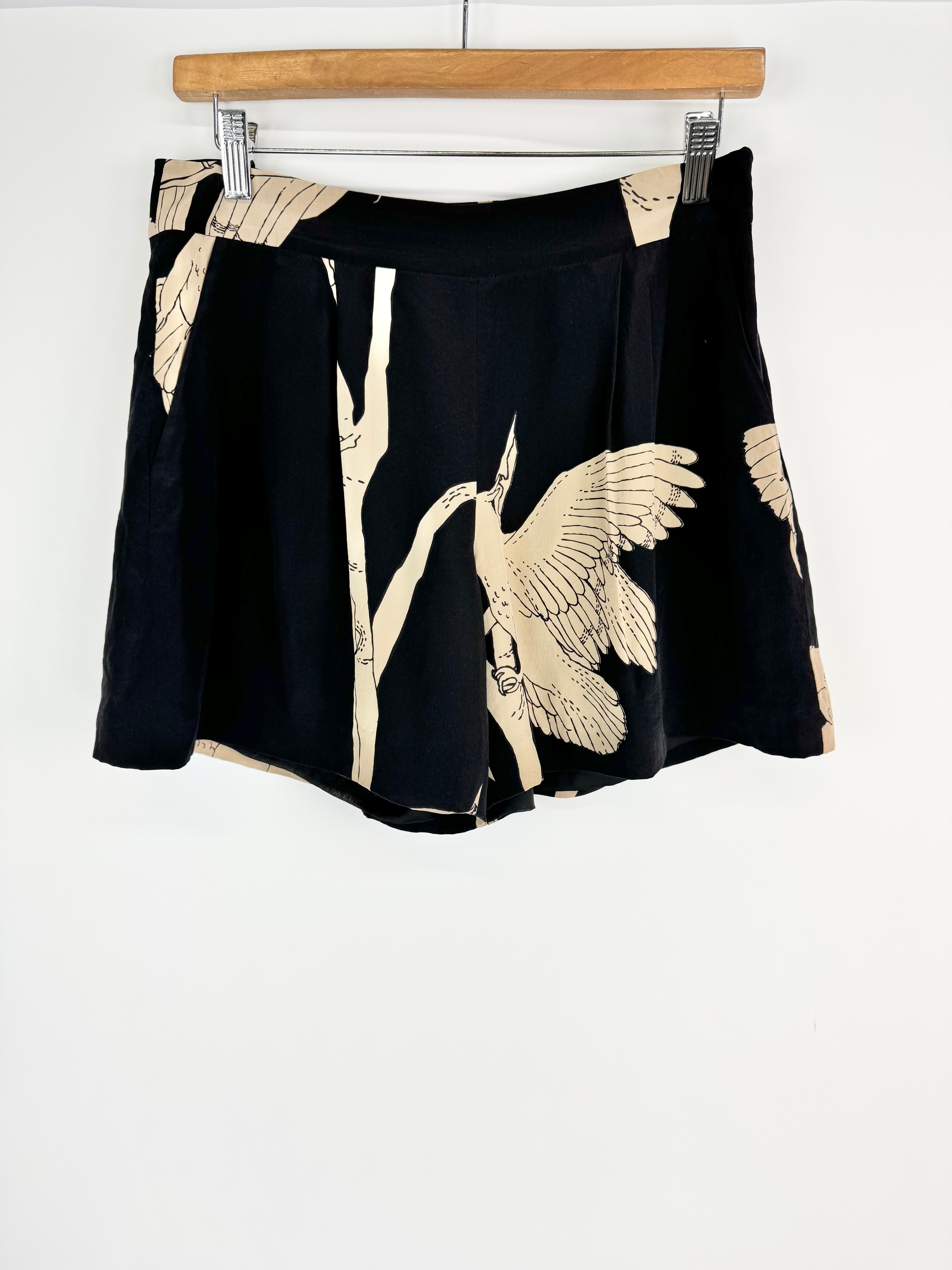 Black skirt with beige bird and branch design on a hanger against a white background