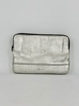 Silver metallic pouch with a brand logo on a gray background