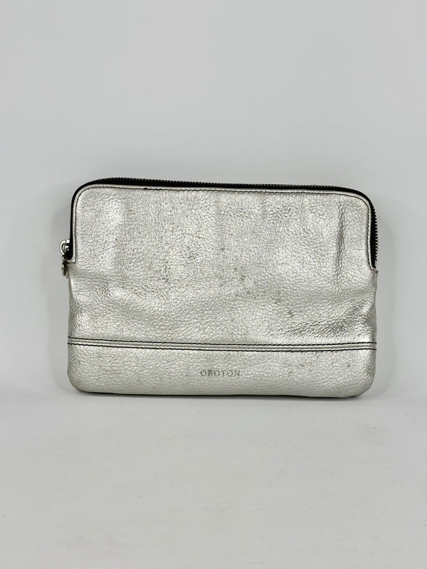 Silver metallic pouch with a brand logo on a gray background