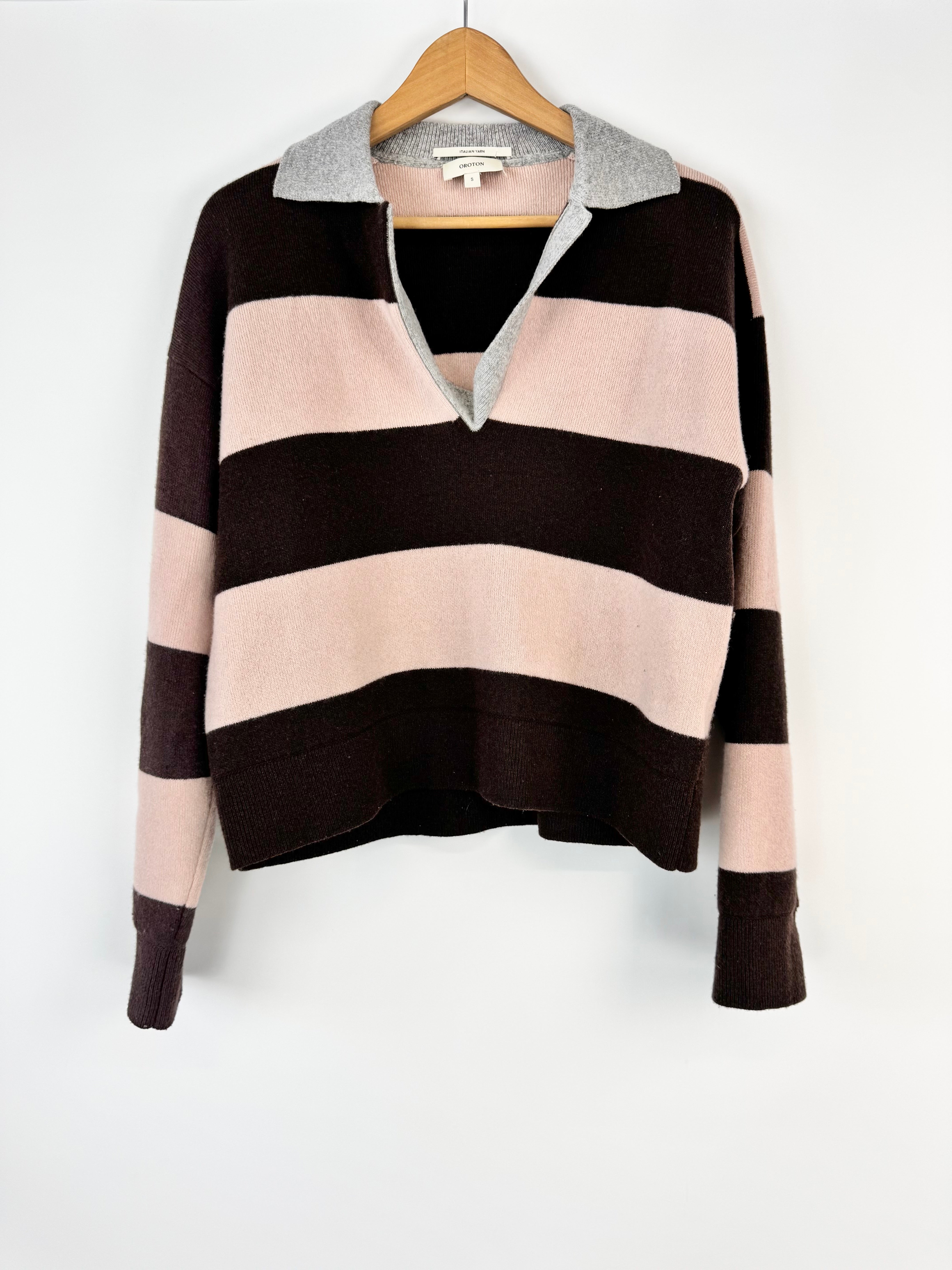 Striped sweater on a hanger against a white background