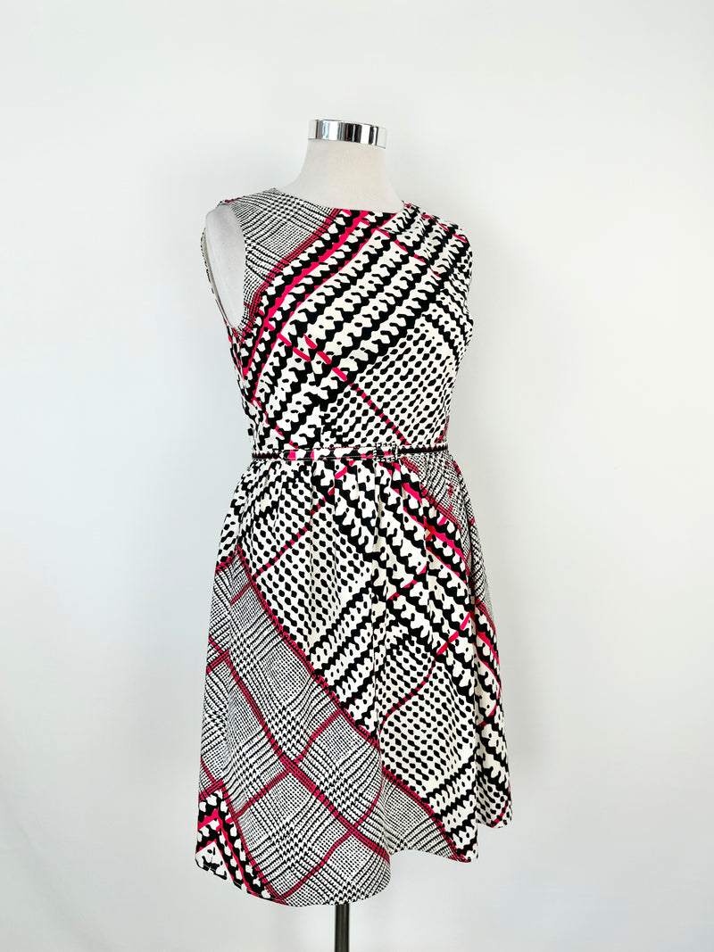 A silk midi dress with a geometric pattern in white, blue, and hot pink, featuring a rounded scoop neckline, zipper at the back, and a fine, small belted tie at the waist.