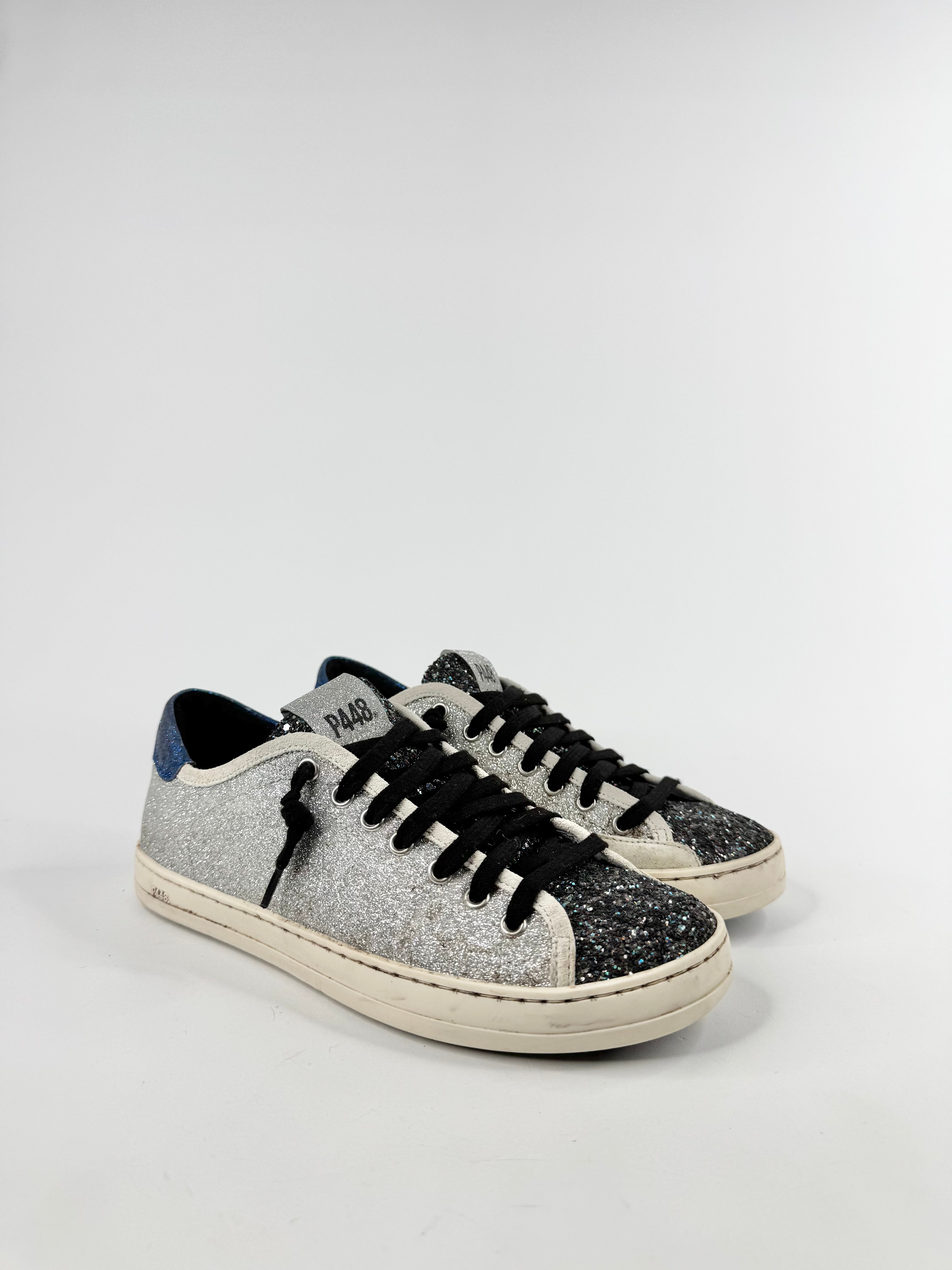 Pair of glittery sneakers with black laces on a white background