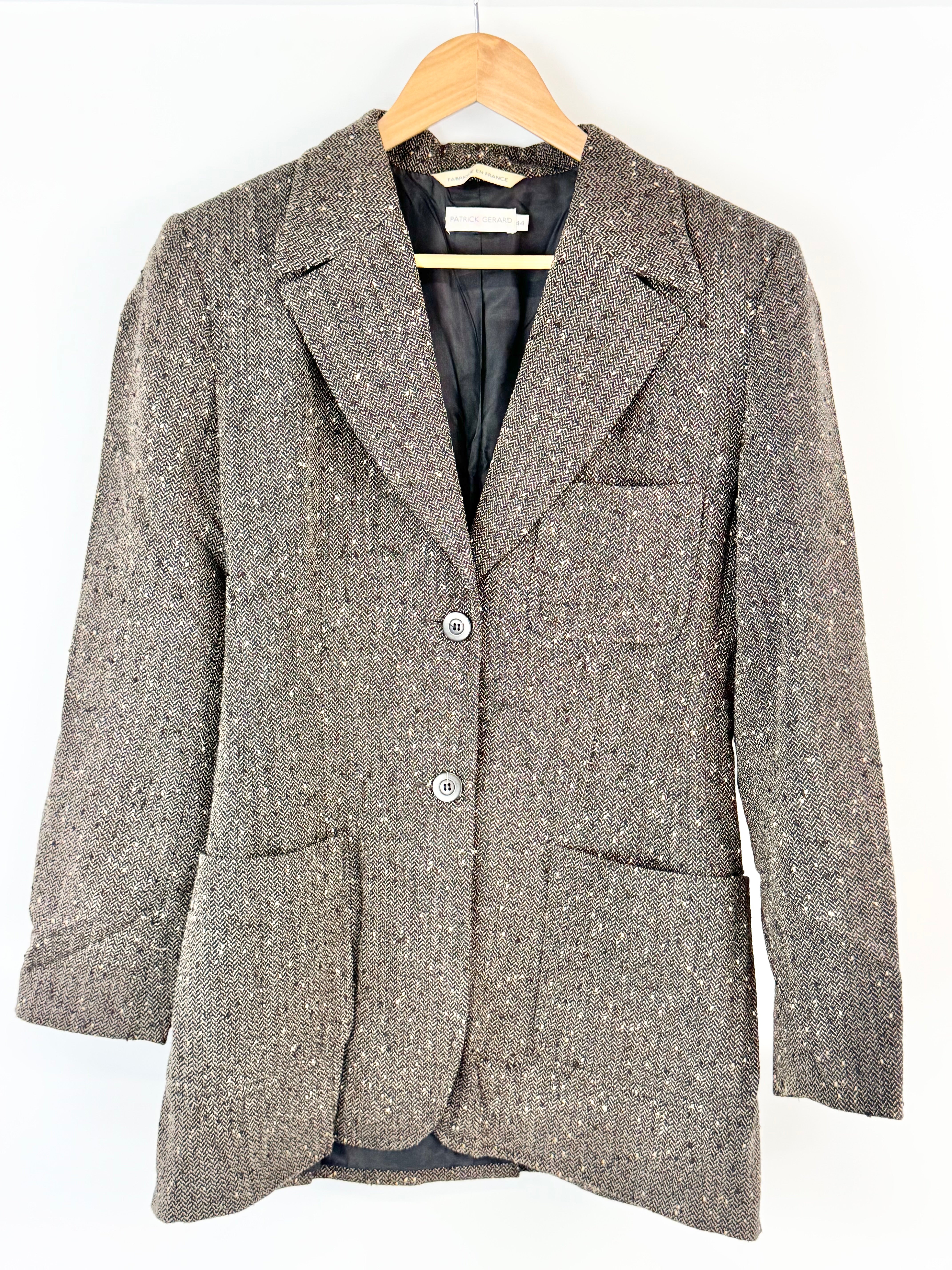 Herringbone blazer on a hanger against a white background