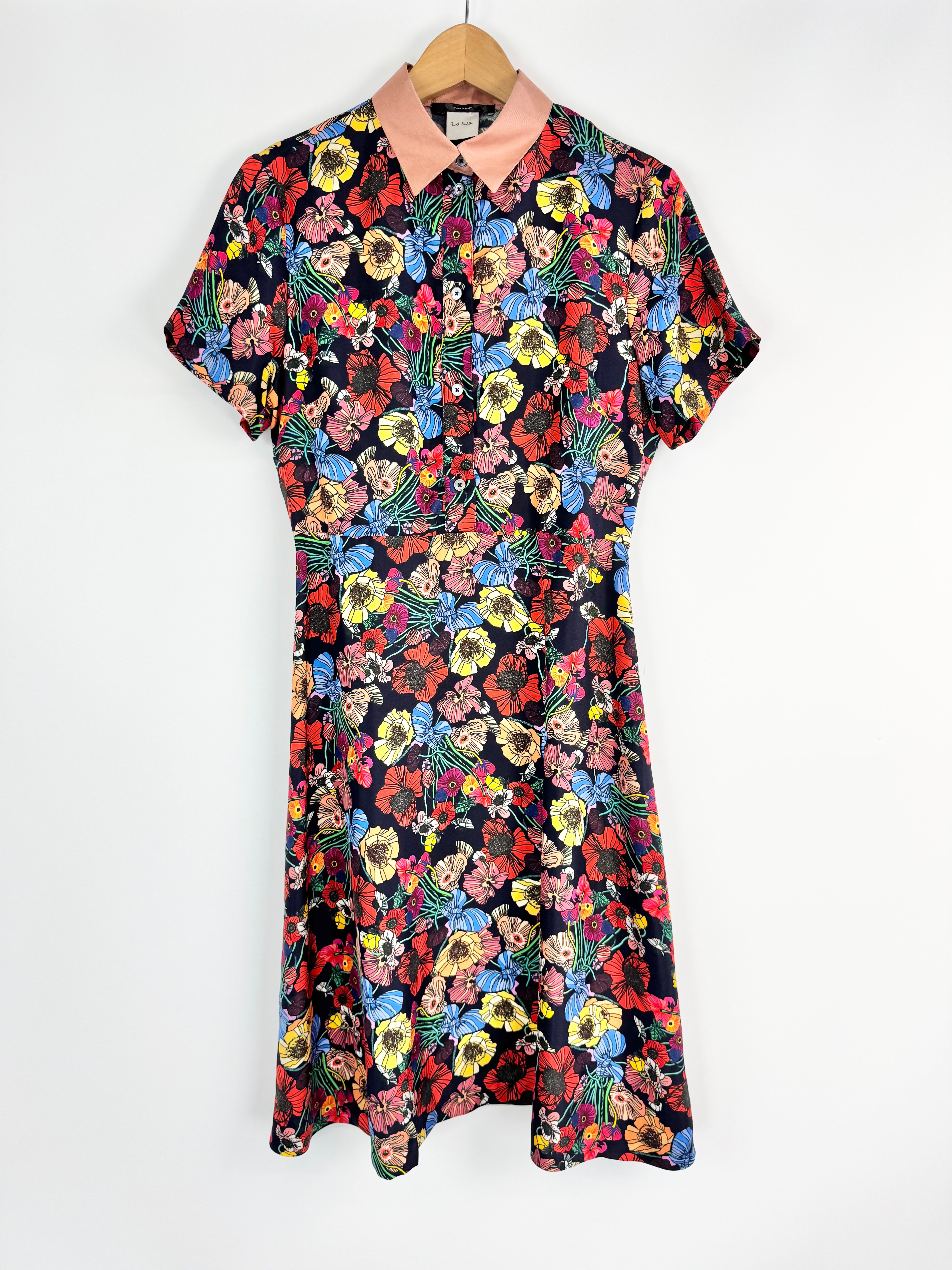 Floral dress on a hanger against a white background