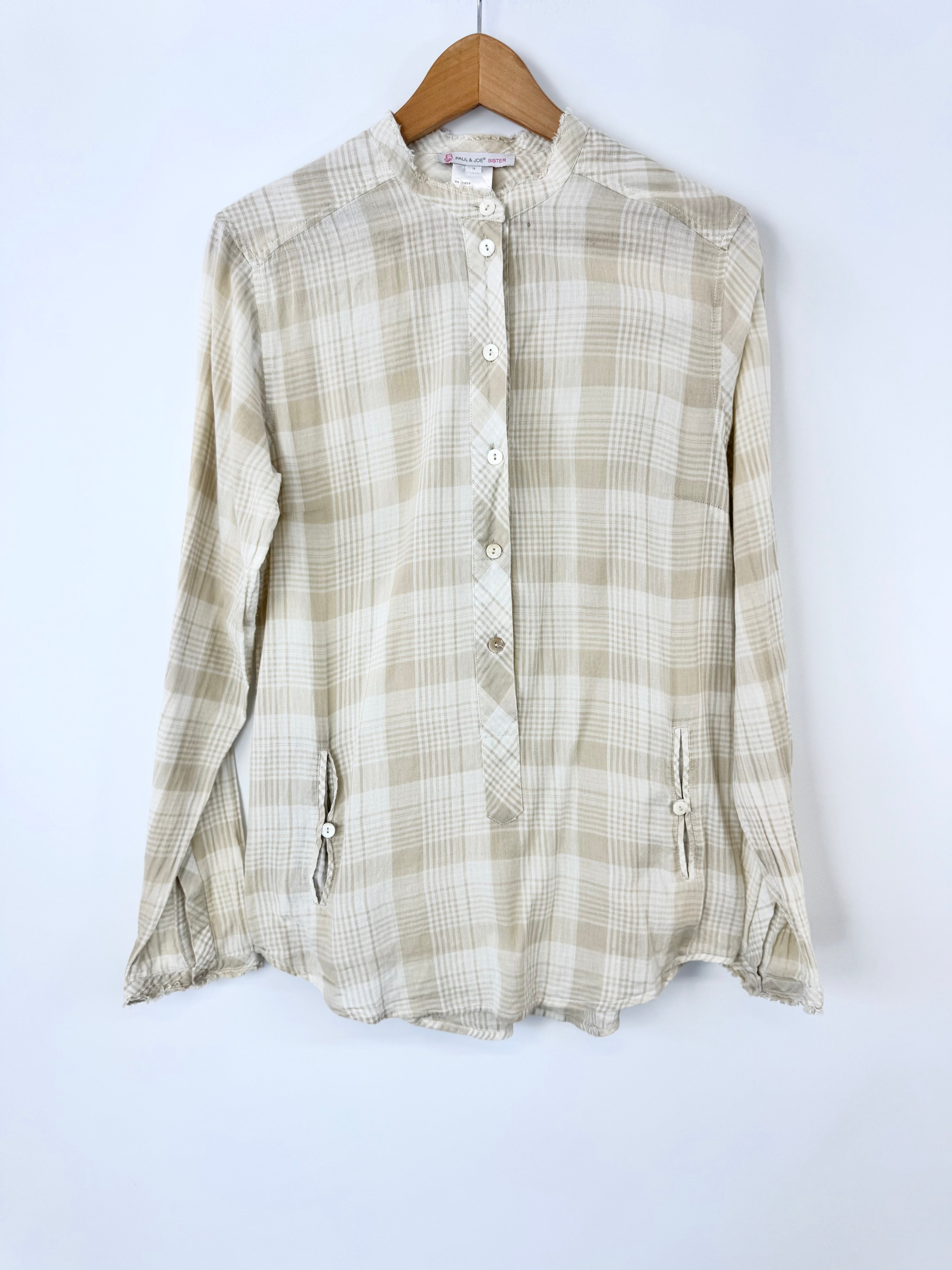 Plaid shirt on a hanger against a white background