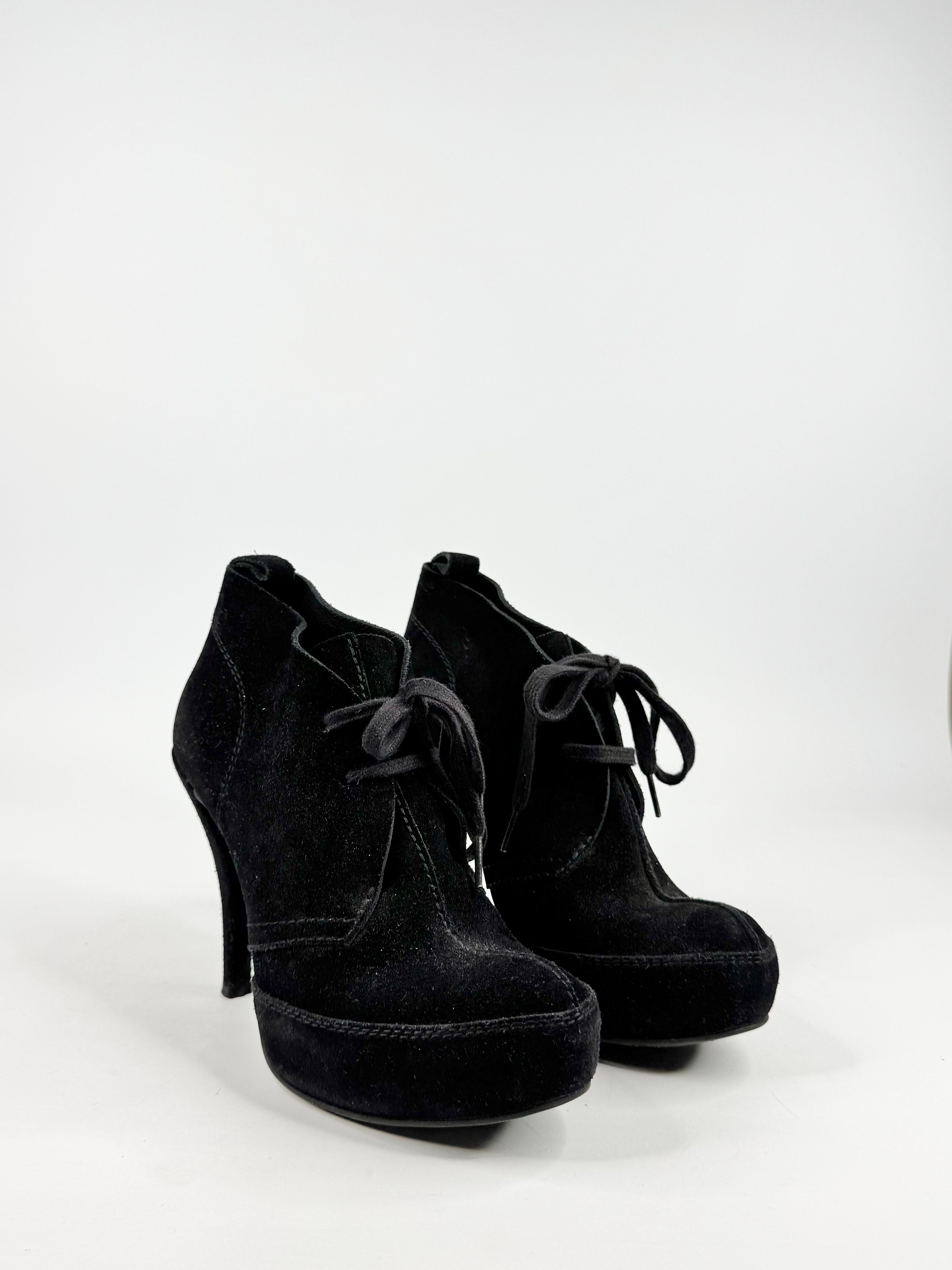 Pair of black suede platform shoes on a white background