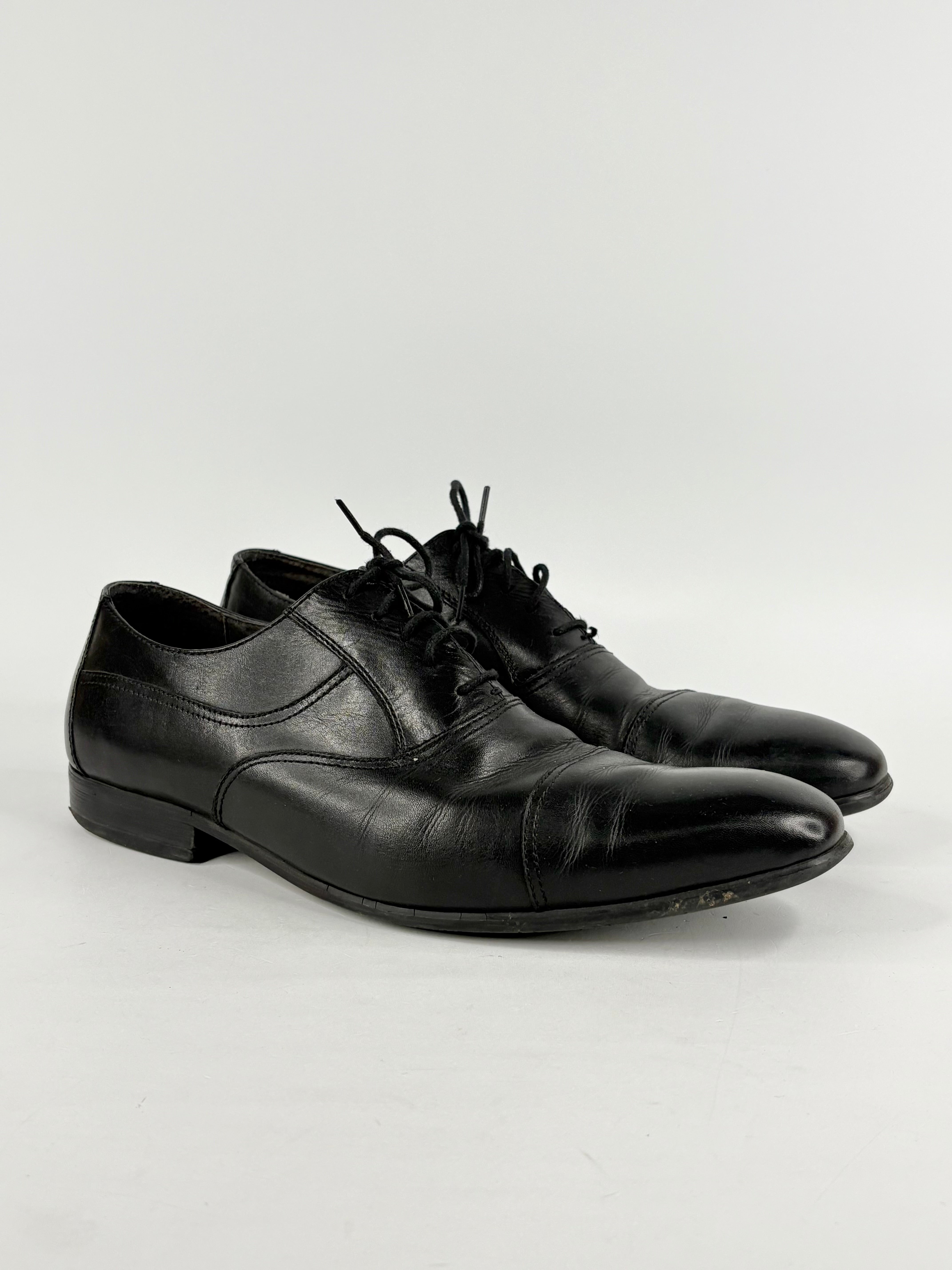 Pair of black leather dress shoes on a white background
