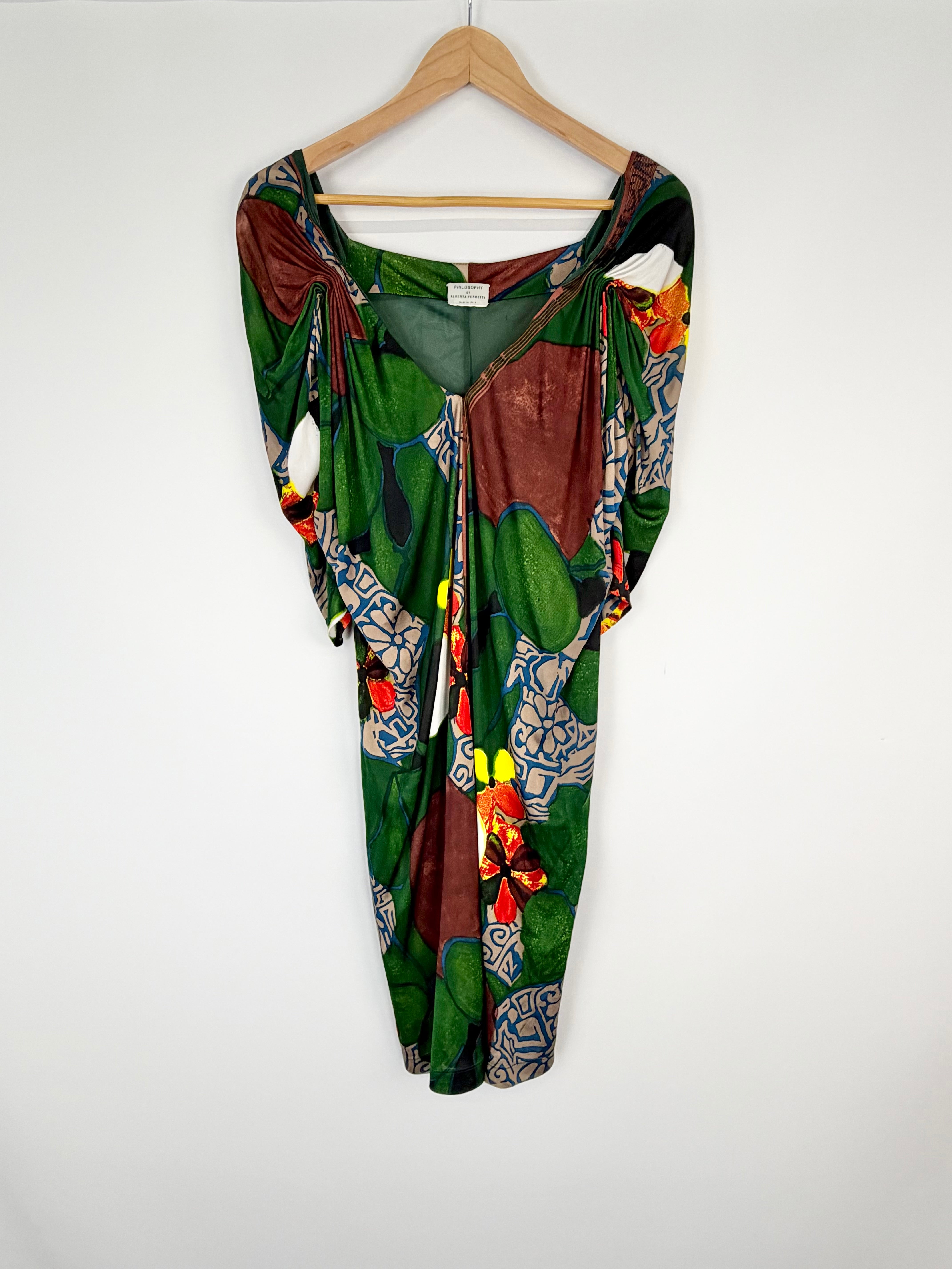 Colorful patterned dress on a hanger against a white background