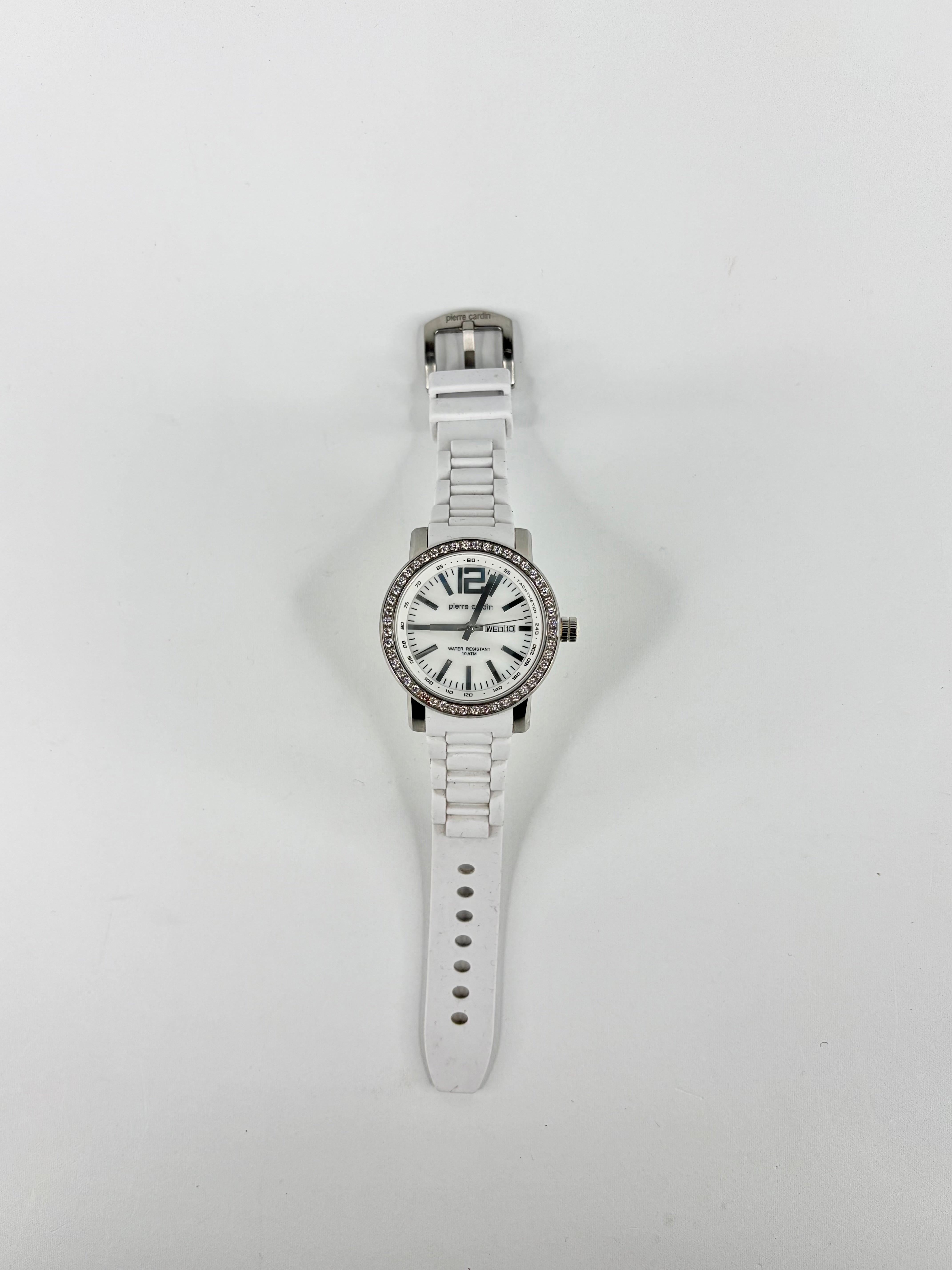 Silver watch with a white face on a light gray background