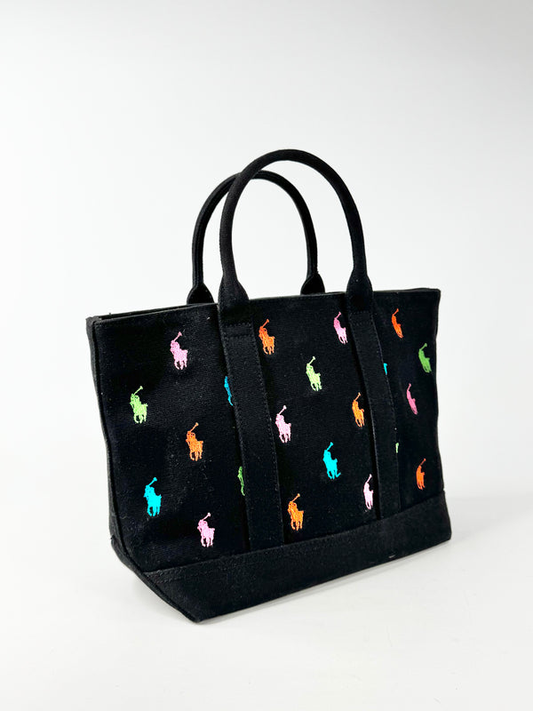 Black tote bag with colorful embroidered designs on a white background