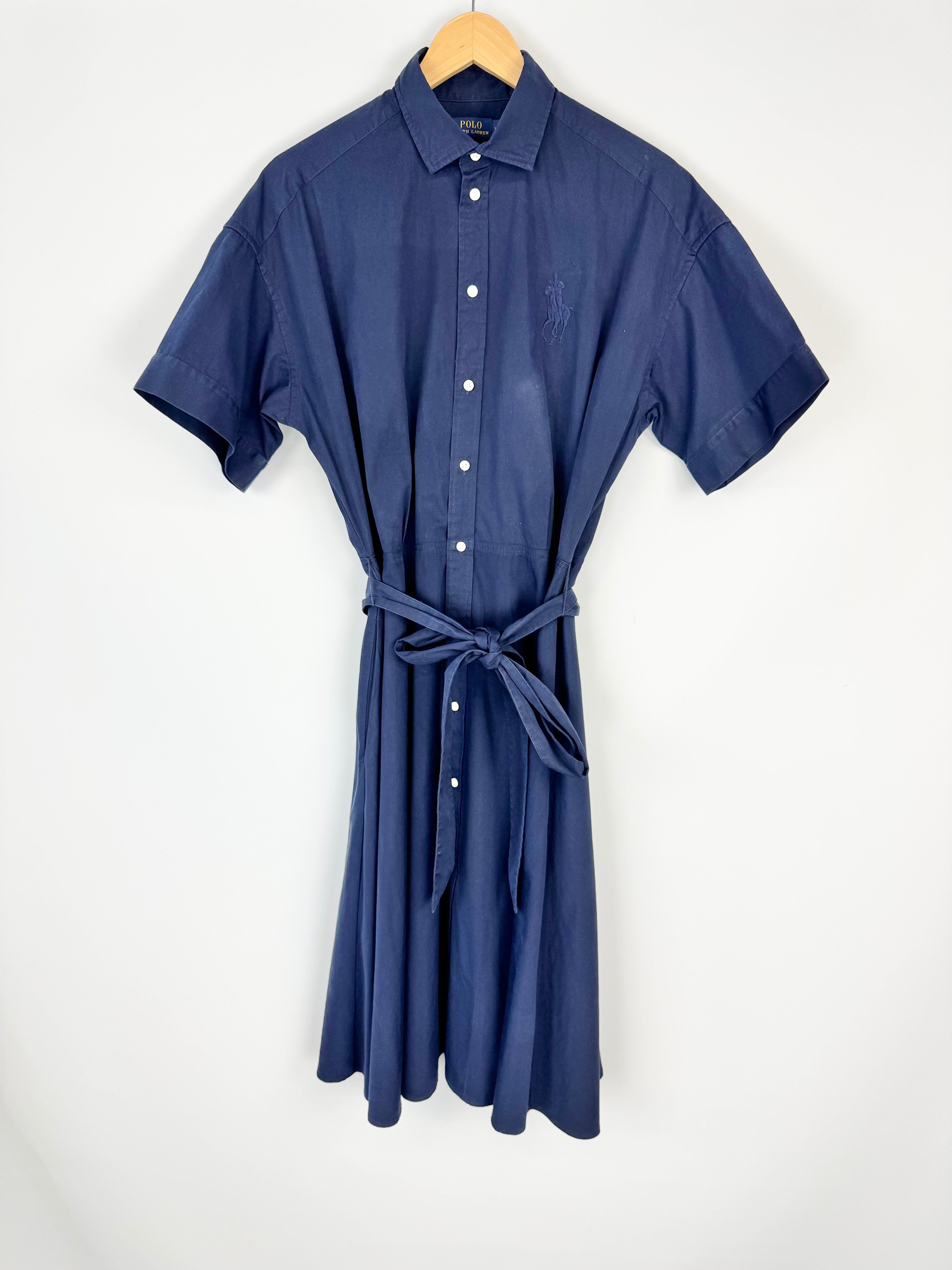 Blue shirt dress on a hanger against a white background
