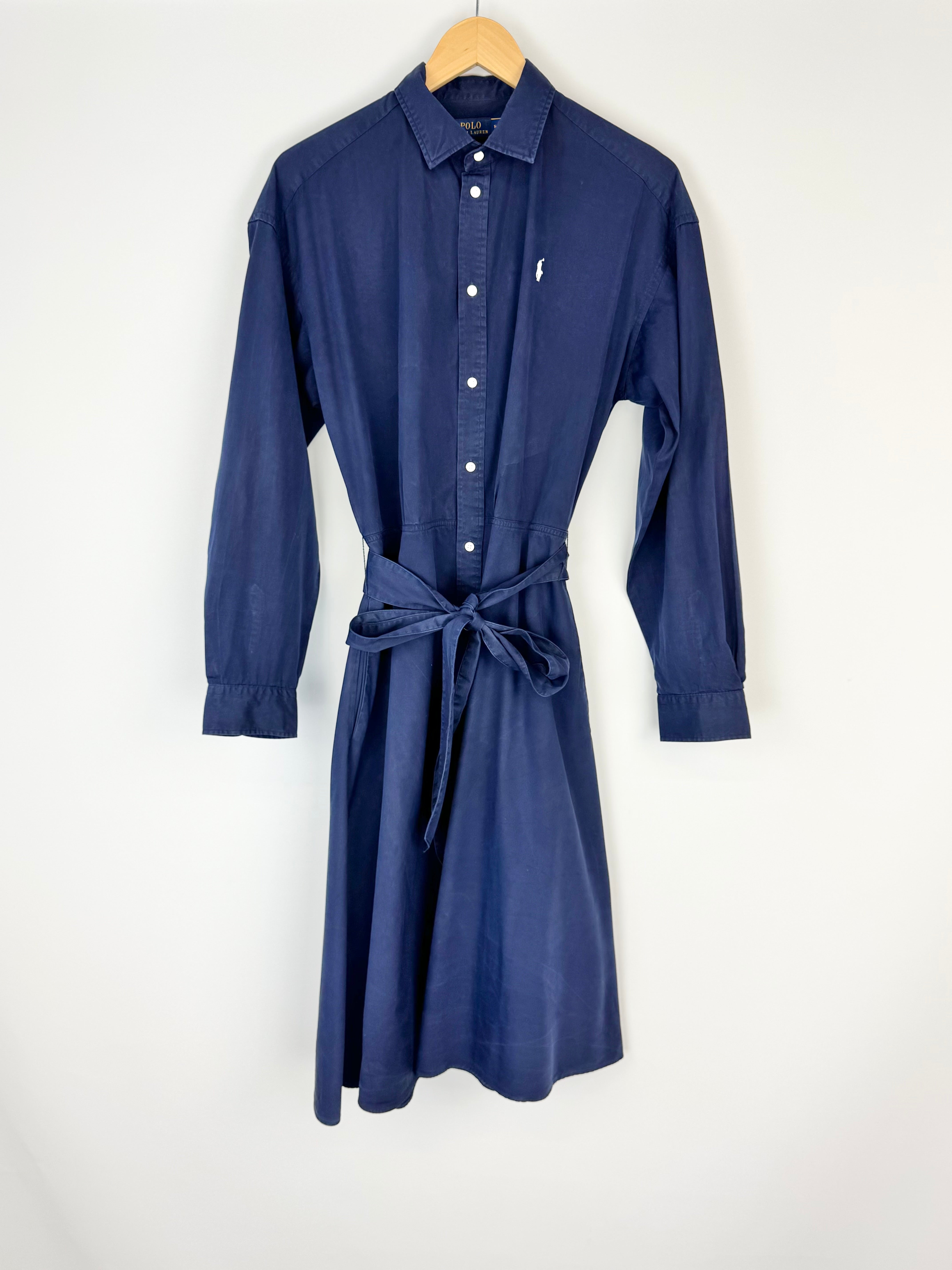 Blue dress on a hanger against a white background