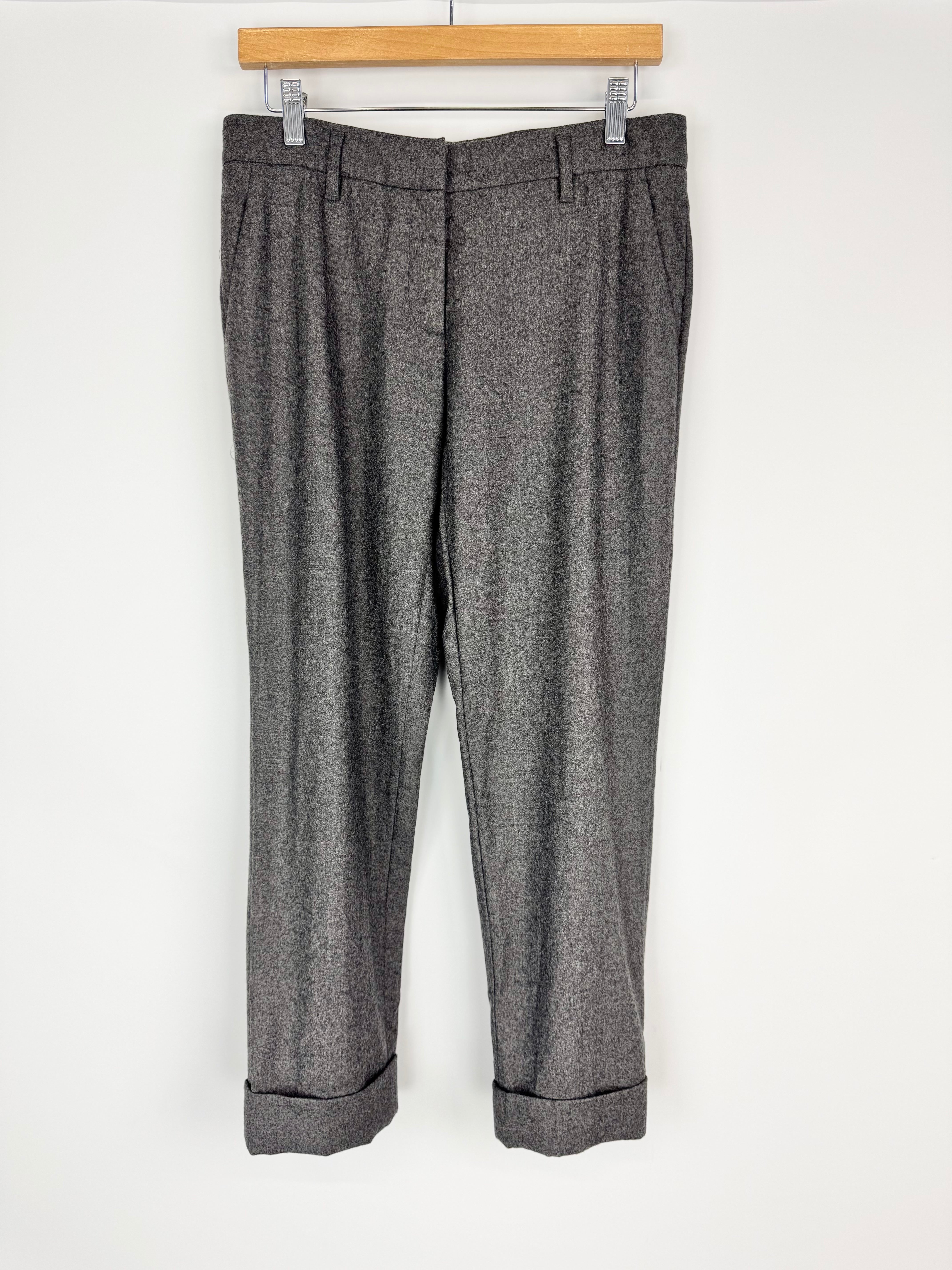 Gray textured pants hanging on a wooden hanger against a white background
