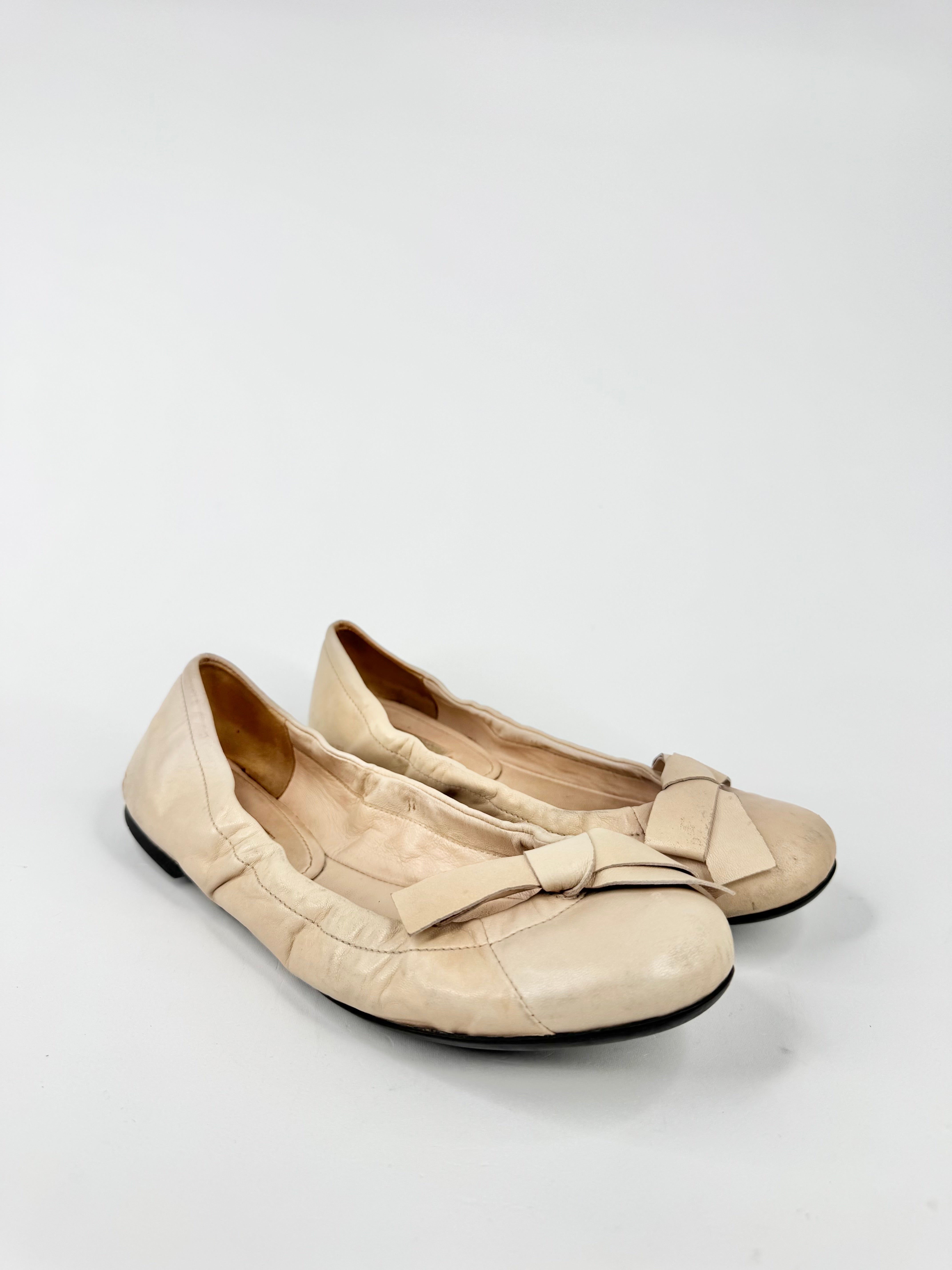 Pair of beige shoes with a bow on a white background