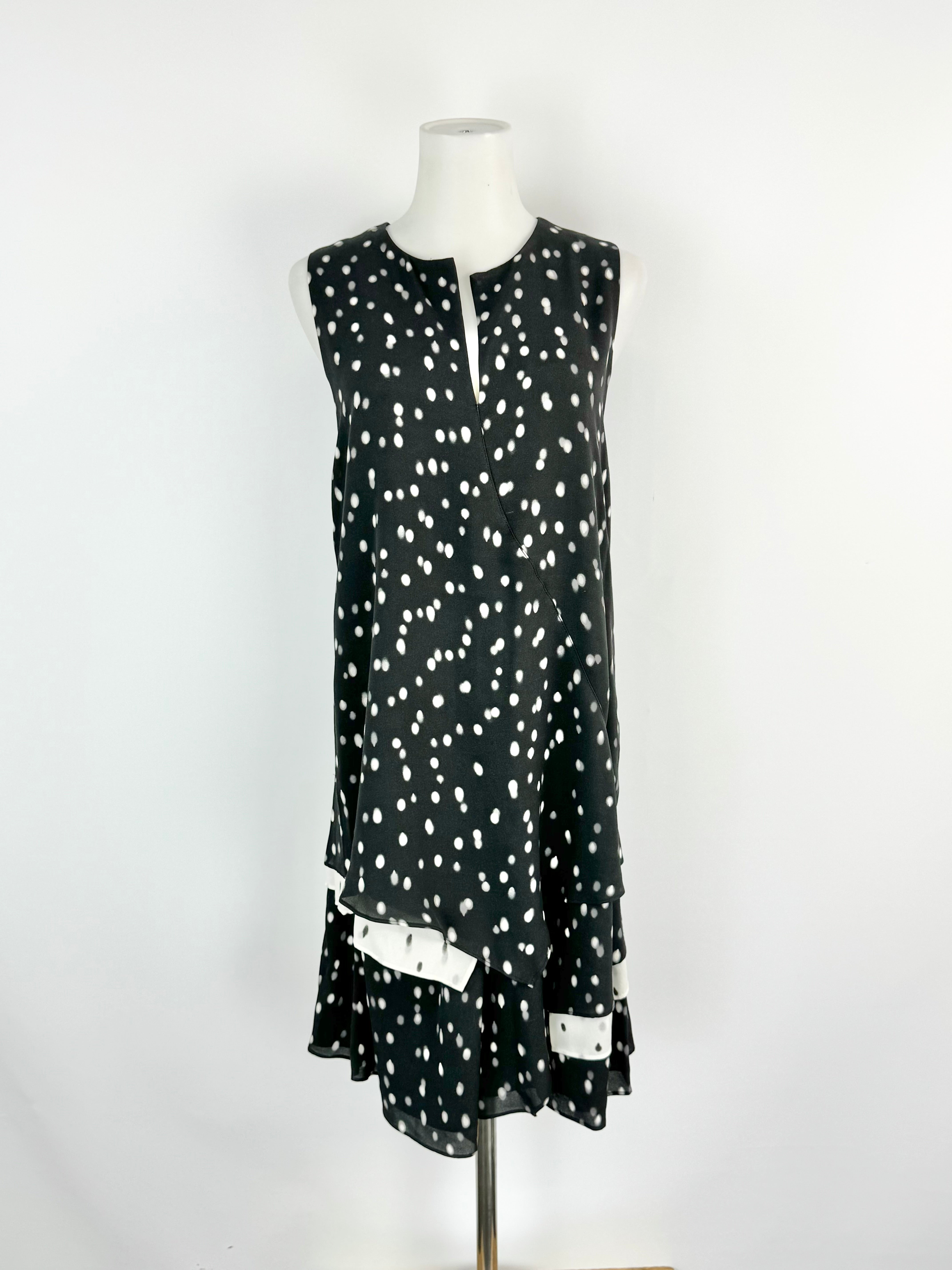 Black dress with white polka dot pattern on a mannequin against a white background
