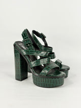 Green platform sandals with crocodile pattern on a white background