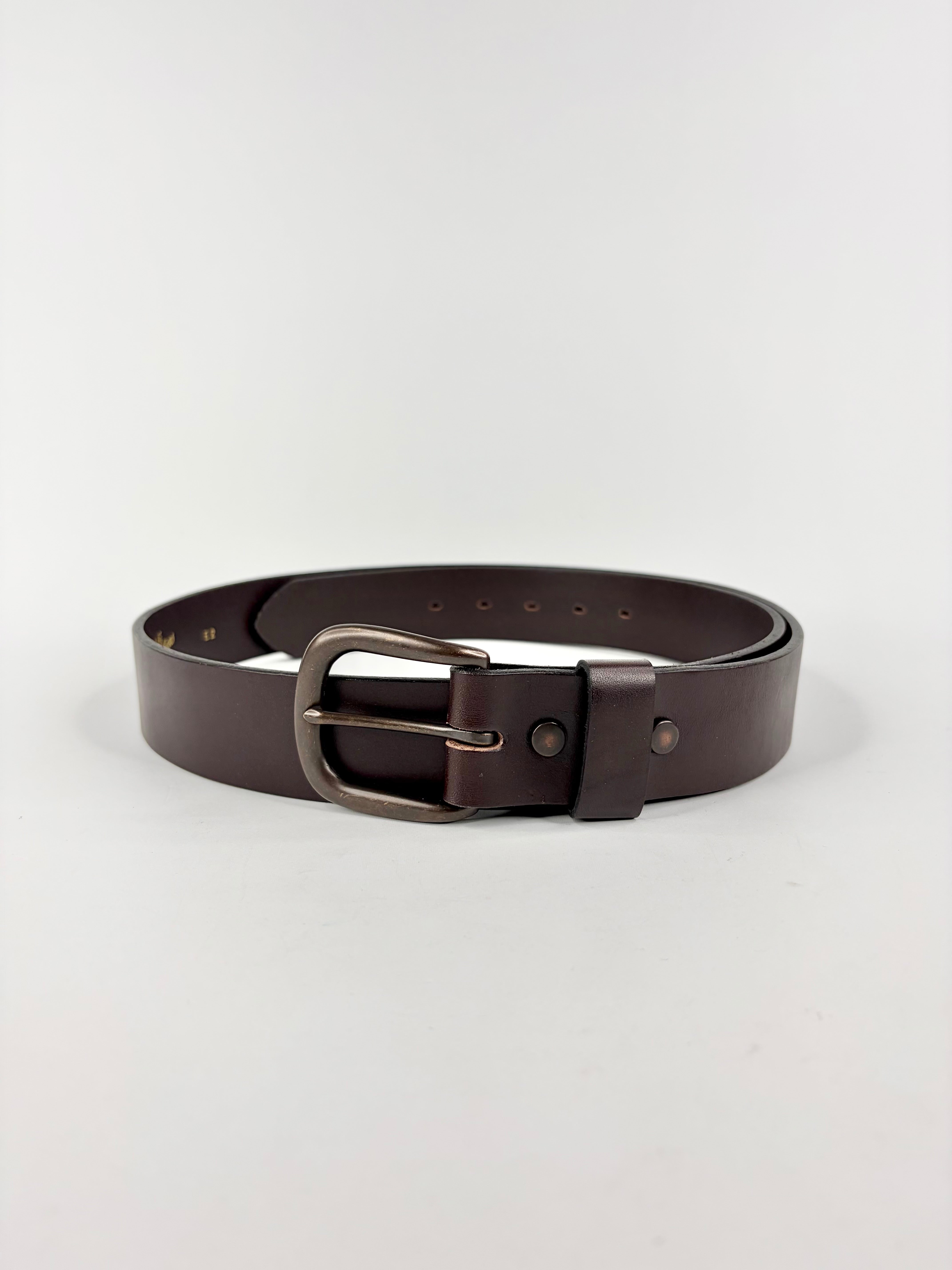 Brown leather belt with a silver buckle on a light gray background