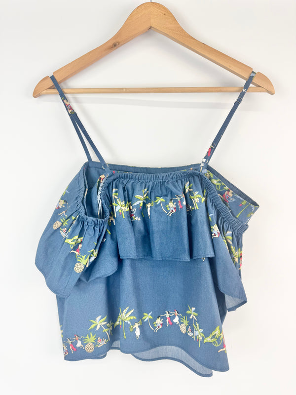 Blue embroidered top on a wooden hanger against a white background