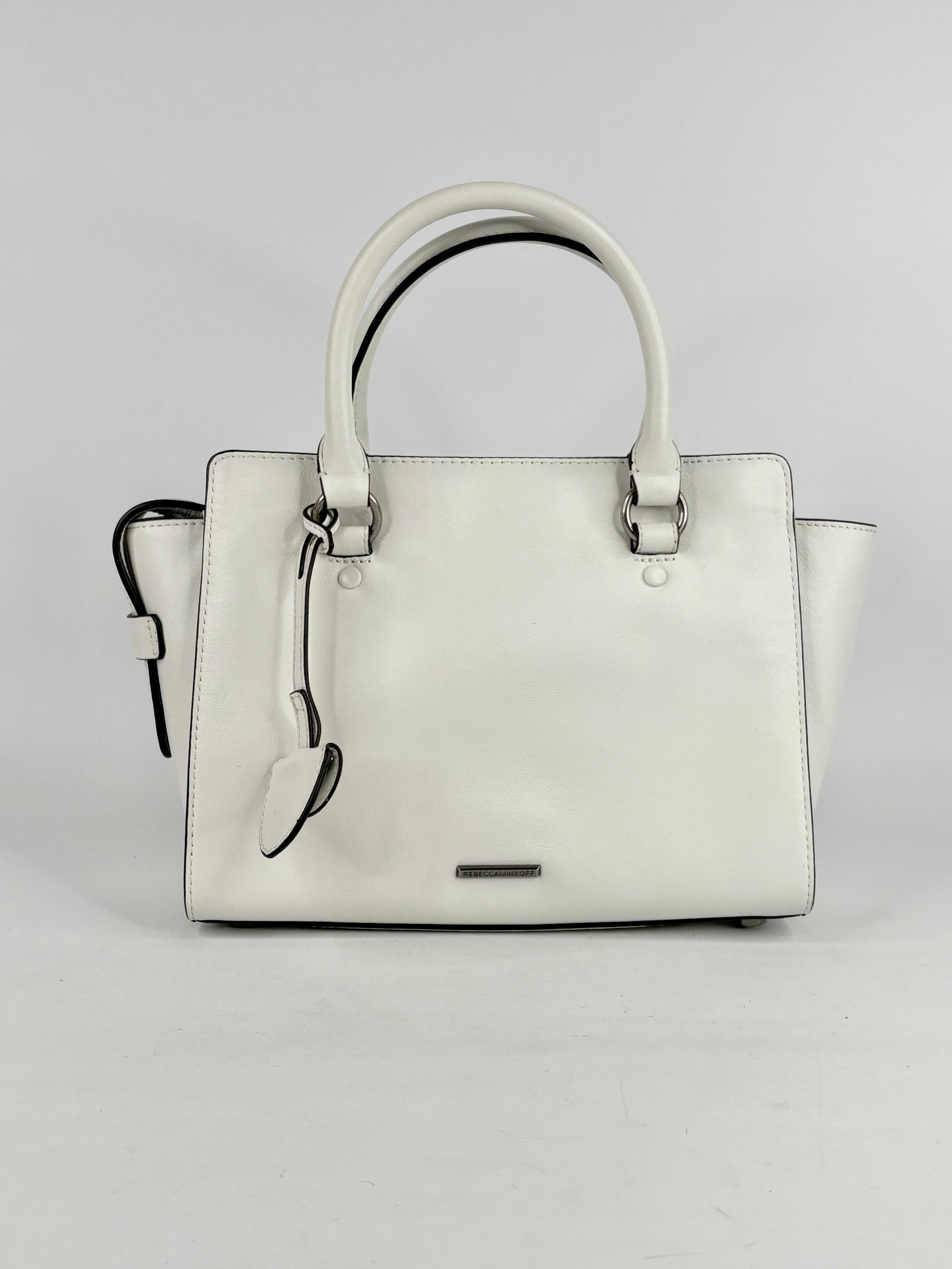 White handbag with black accents on a light gray background