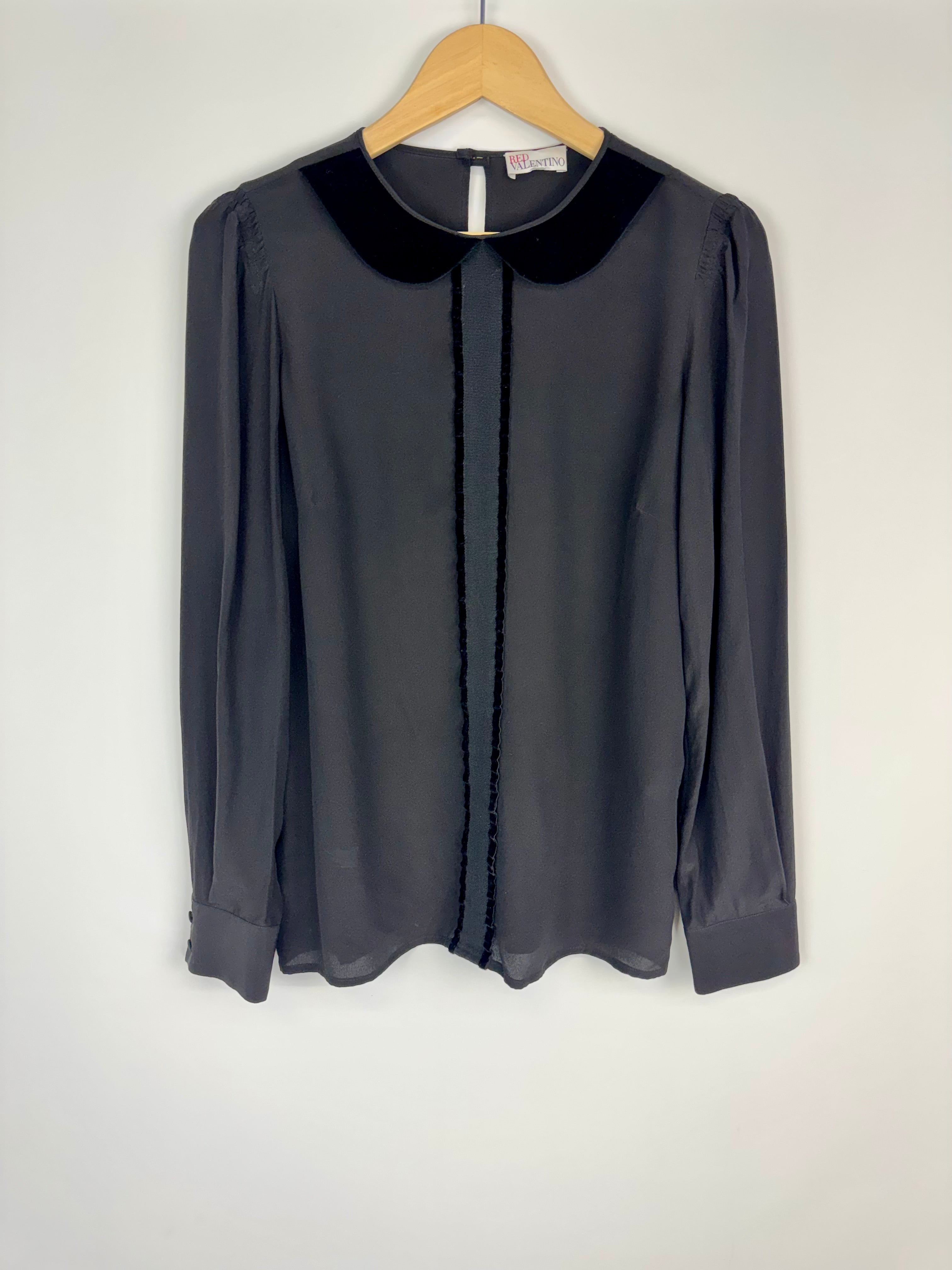 Dark gray blouse with black collar on a hanger against a white background